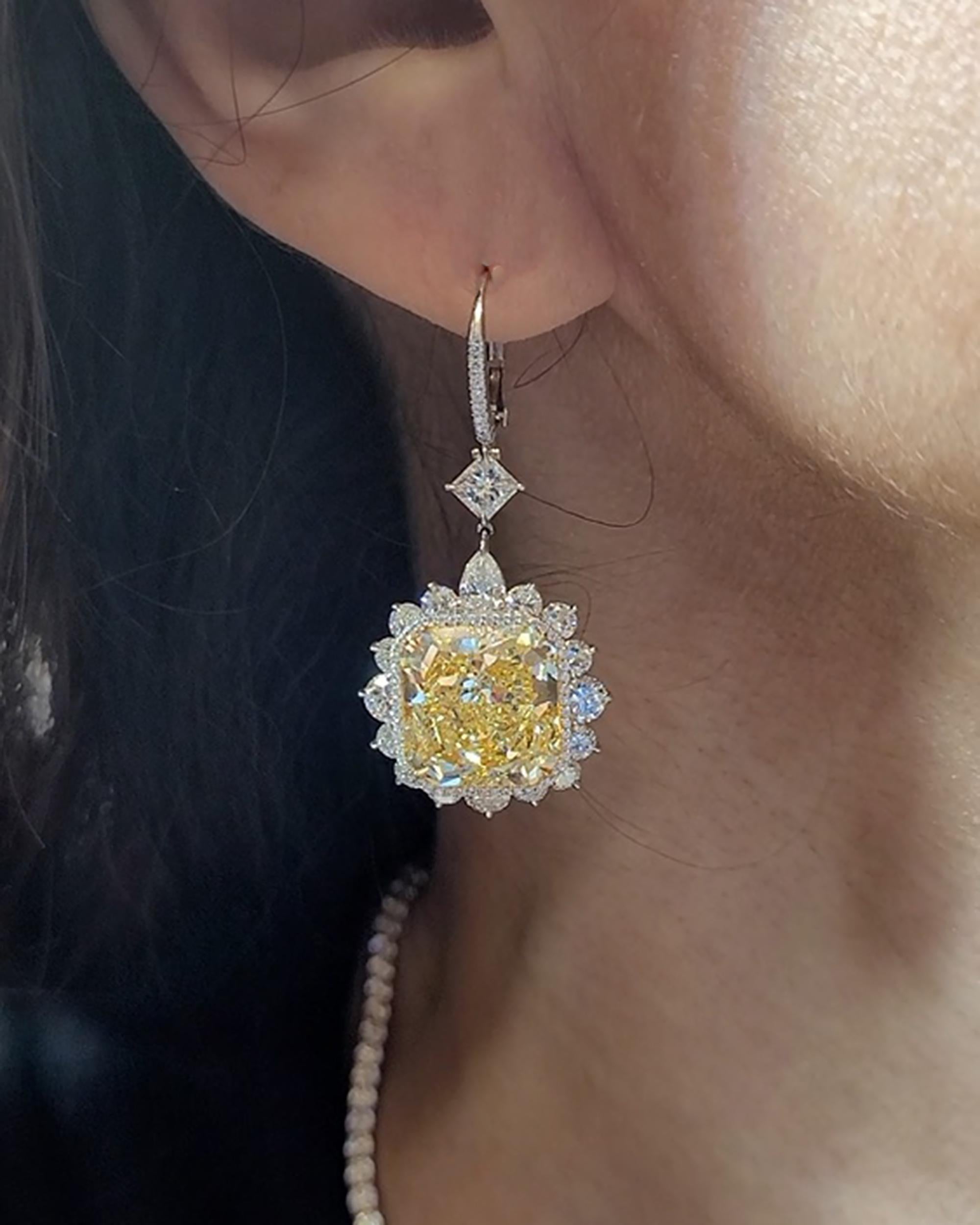 A pair of important earrings featuring two radiant fancy yellow diamonds in the center - 10.16 carats and 10.61 carats.
The yellow diamonds are certified by GIA, stating that they are of VVS2 clarity.
The center stones are surrounded by 34 mixed cut