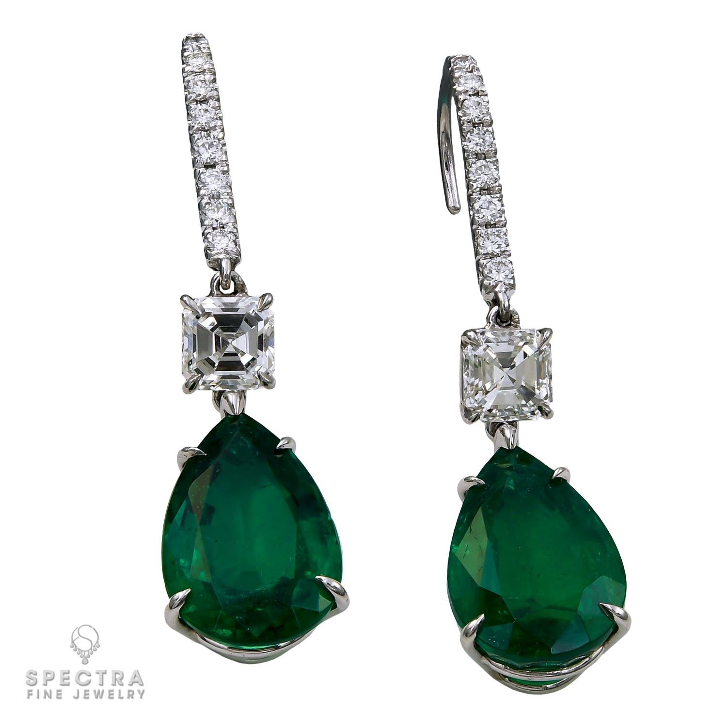 These contemporary Zambian Emerald Diamond Drop Earrings feature exquisite pear-shaped green emeralds totaling 10 carats, set in platinum with 1.00 carat total square emerald-cut white diamonds hovering above. Accented with round brilliant-cut