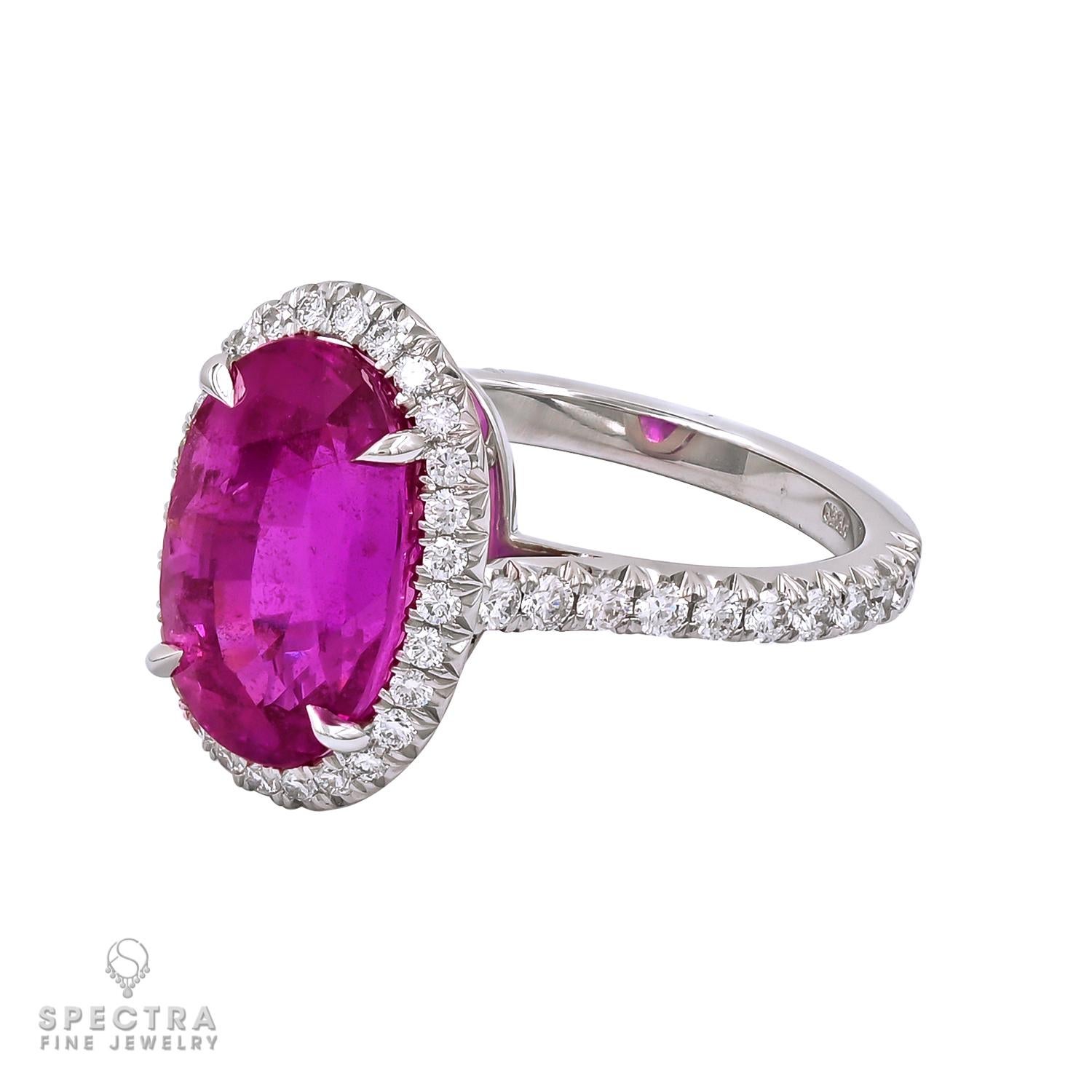 This Contemporary Madagascar Pink Sapphire Diamond Halo Engagement/Cocktail Ring, made by Spectra Fine Jewelry in the 21st century, is crafted from platinum and features an utterly unique oval faceted pink sapphire with an estimated weight of 7.16