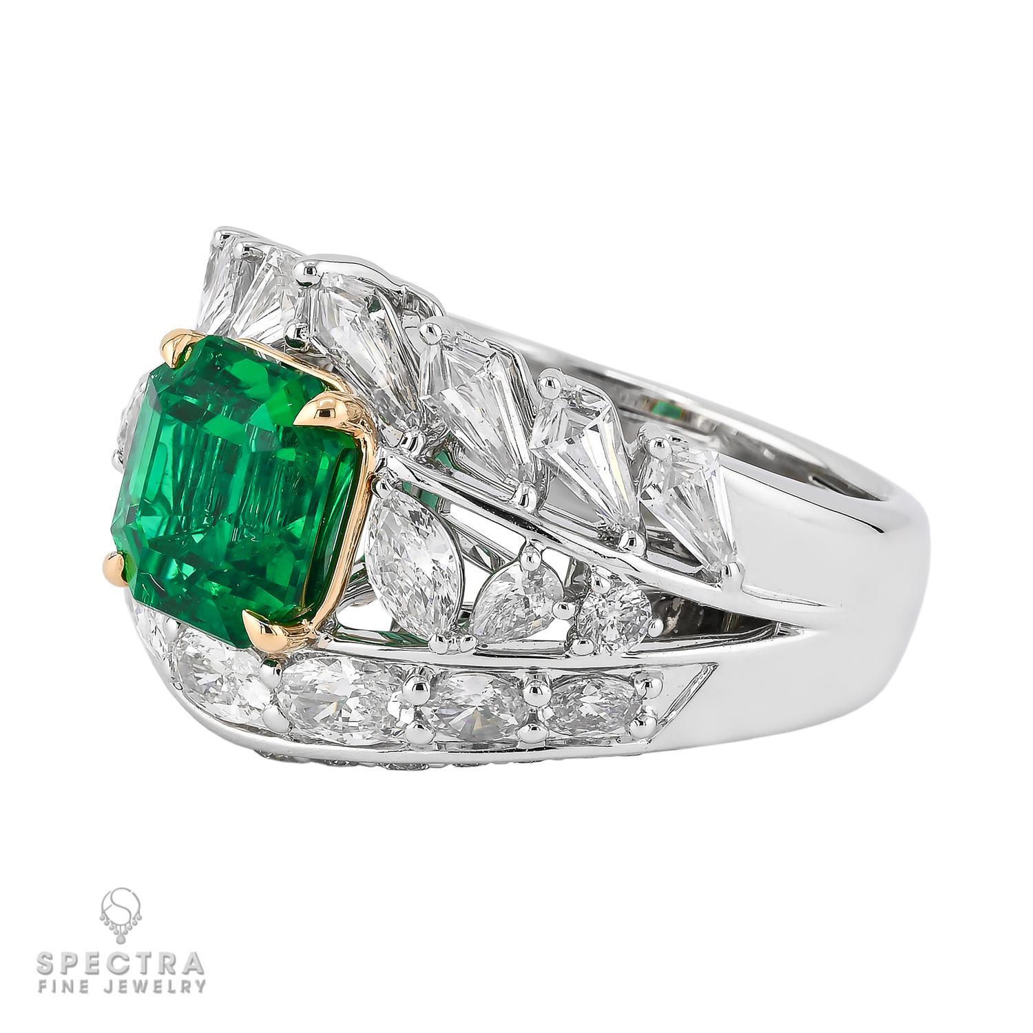 This exquisite cocktail ring from Spectra Fine Jewelry features a captivating 2.11-carat emerald-cut Colombian emerald, certified by SSEF for its no-oil clarity, ensuring its natural beauty shines through. Surrounded by 1.89 carats of mixed-shape