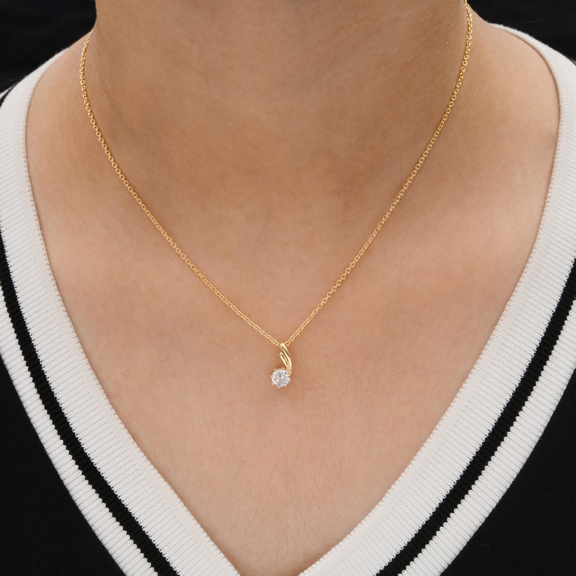 Le collier à chaîne pendante en or jaune 18 carats et diamant SI/H brillant présente un pendentif en diamant de forme ronde, tandis que l'arc en or incurvé s'étend délicatement au-dessus de lui.
Les diamants sont un symbole universel d'éternité et