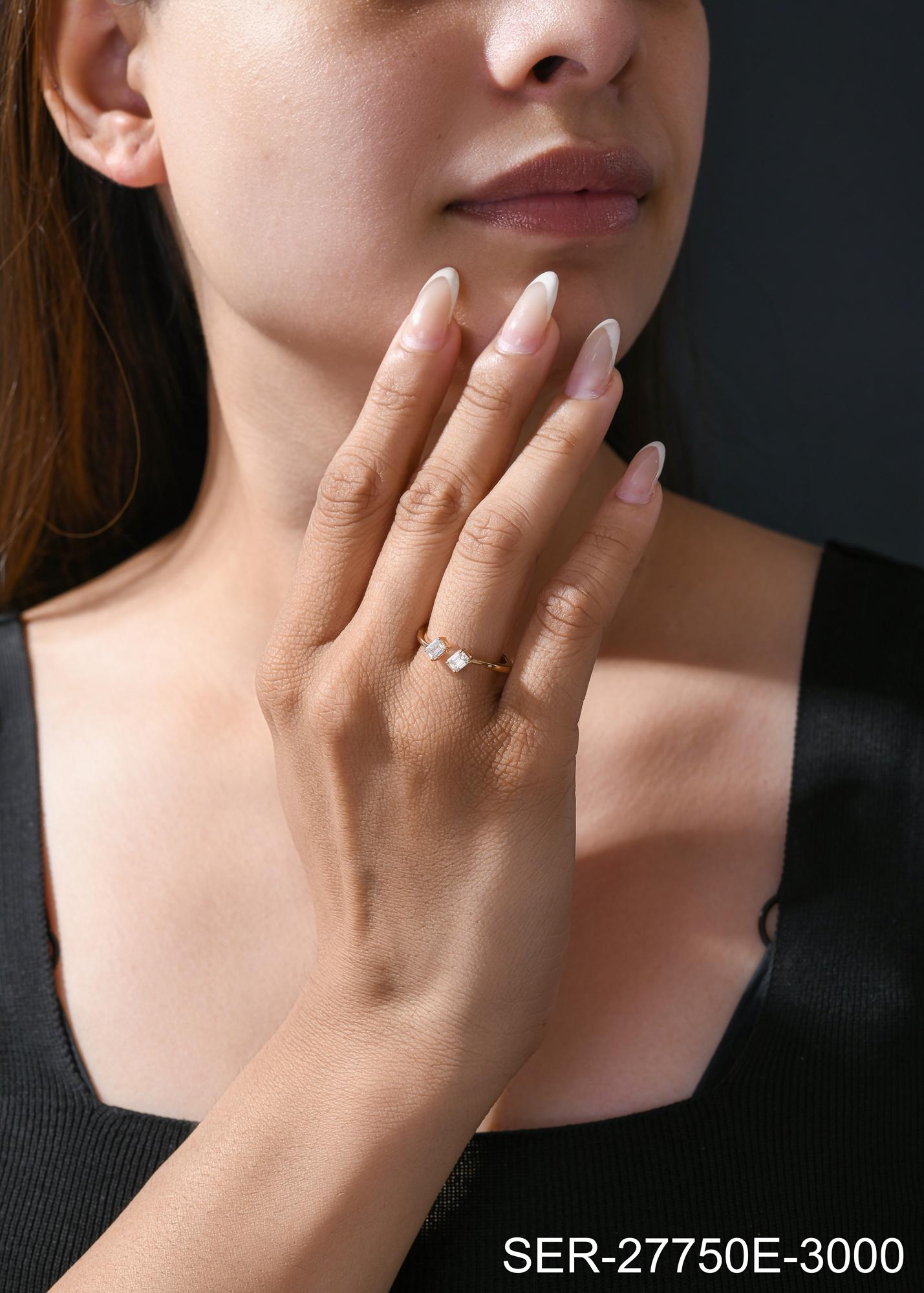 La bague Toi et Moi en or jaune 18 carats à diamant taille émeraude présente des courbes douces qui encadrent deux diamants taille émeraude placés l'un en face de l'autre aux extrémités ouvertes.
Les diamants sont un symbole universel d'éternité et