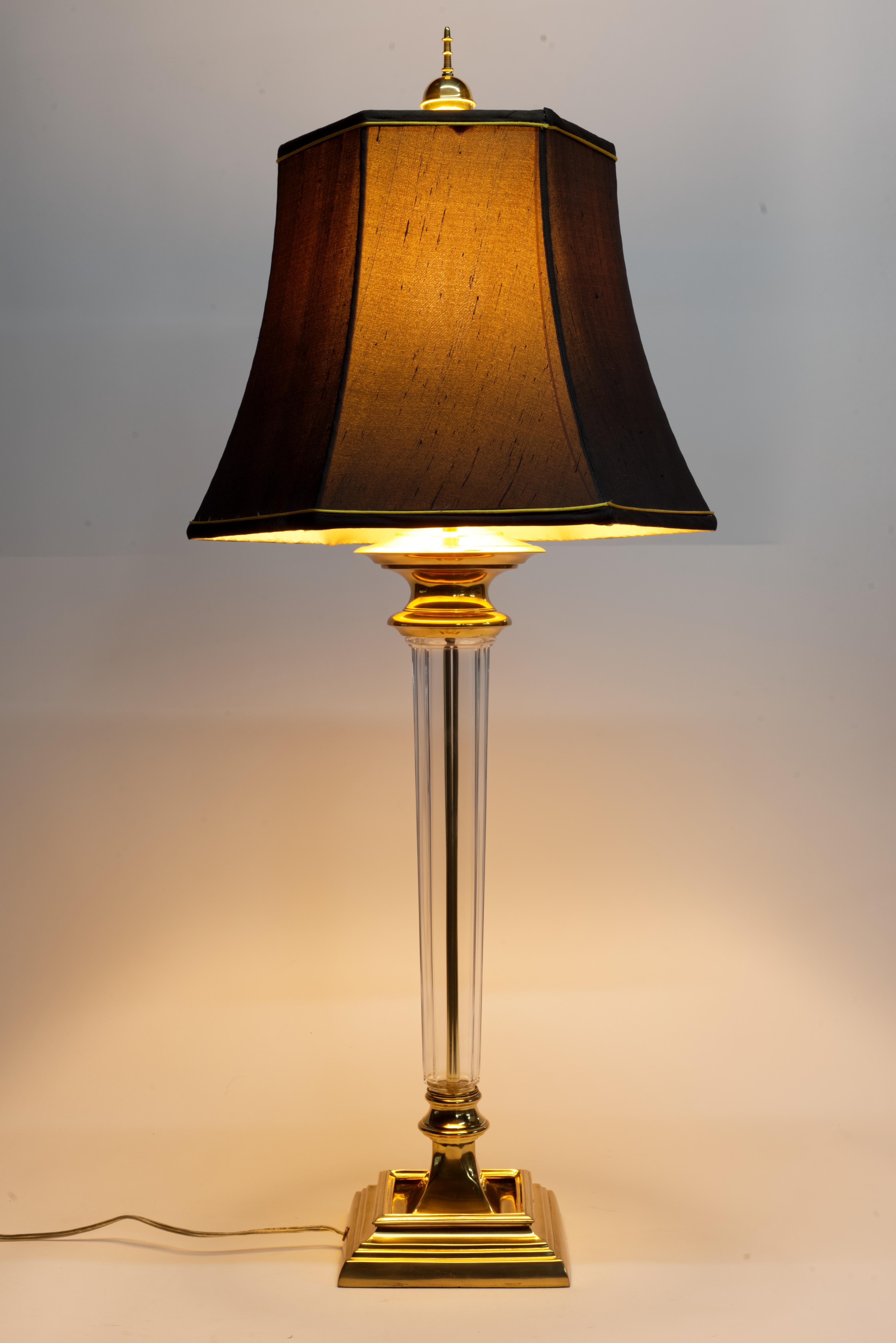  Die hohe, skulpturale Vintage-Tischleuchte Speer zeichnet sich durch einen länglichen Kristallglaskörper mit einer grafischen Bronzeplatte aus, die auf einem detailreichen Bronzesockel montiert ist und eine fackelförmige Silhouette bildet. Sie ist