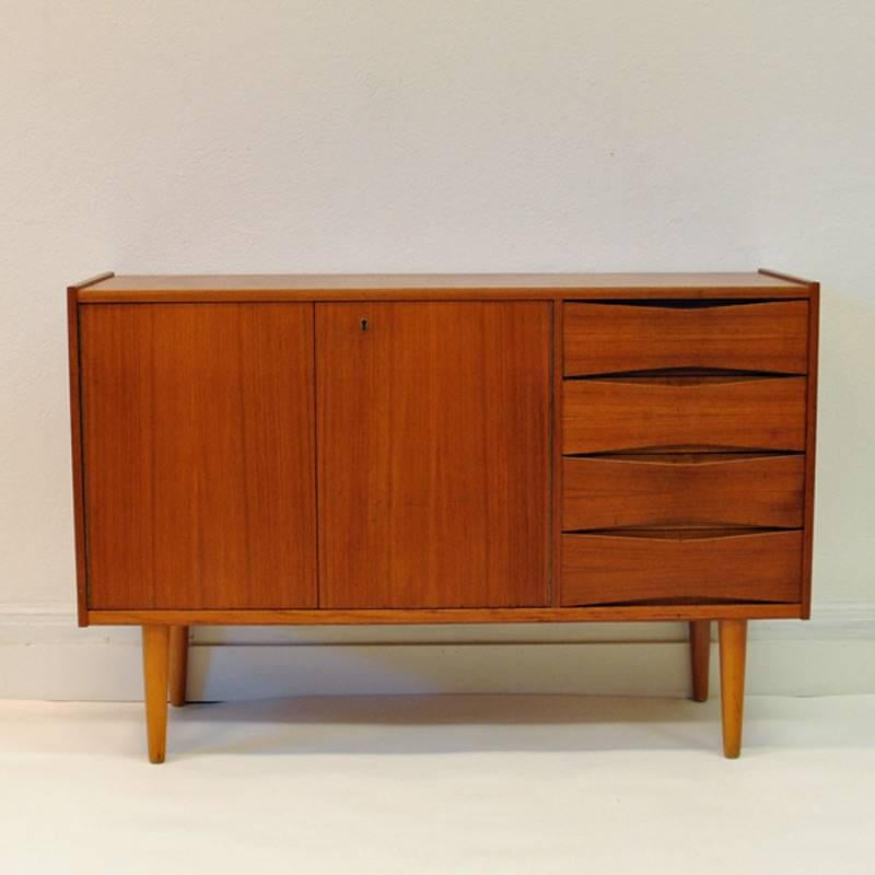 Elegant nice little teak sideboard that fits everywhere named Spekter designed by Fredrik Kayser and manufactured by Skeie & Co. A/S Møbelfabrik, Norway in the 1960s.
The sideboard has adjustable shelves to the left and four pieces bow tie drawers