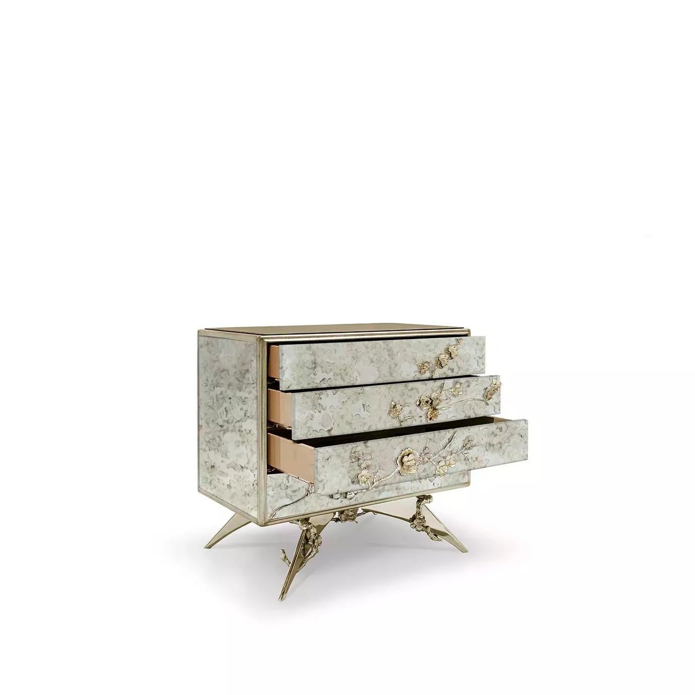 There is a sense of reveal and conceal as KOKET takes a beautiful nightstand in aged mirror and adorns it in metal organic lace, revealing a mesmerizing hint of what lies beneath. Four drawers embellished with organic hardware.

Materials &