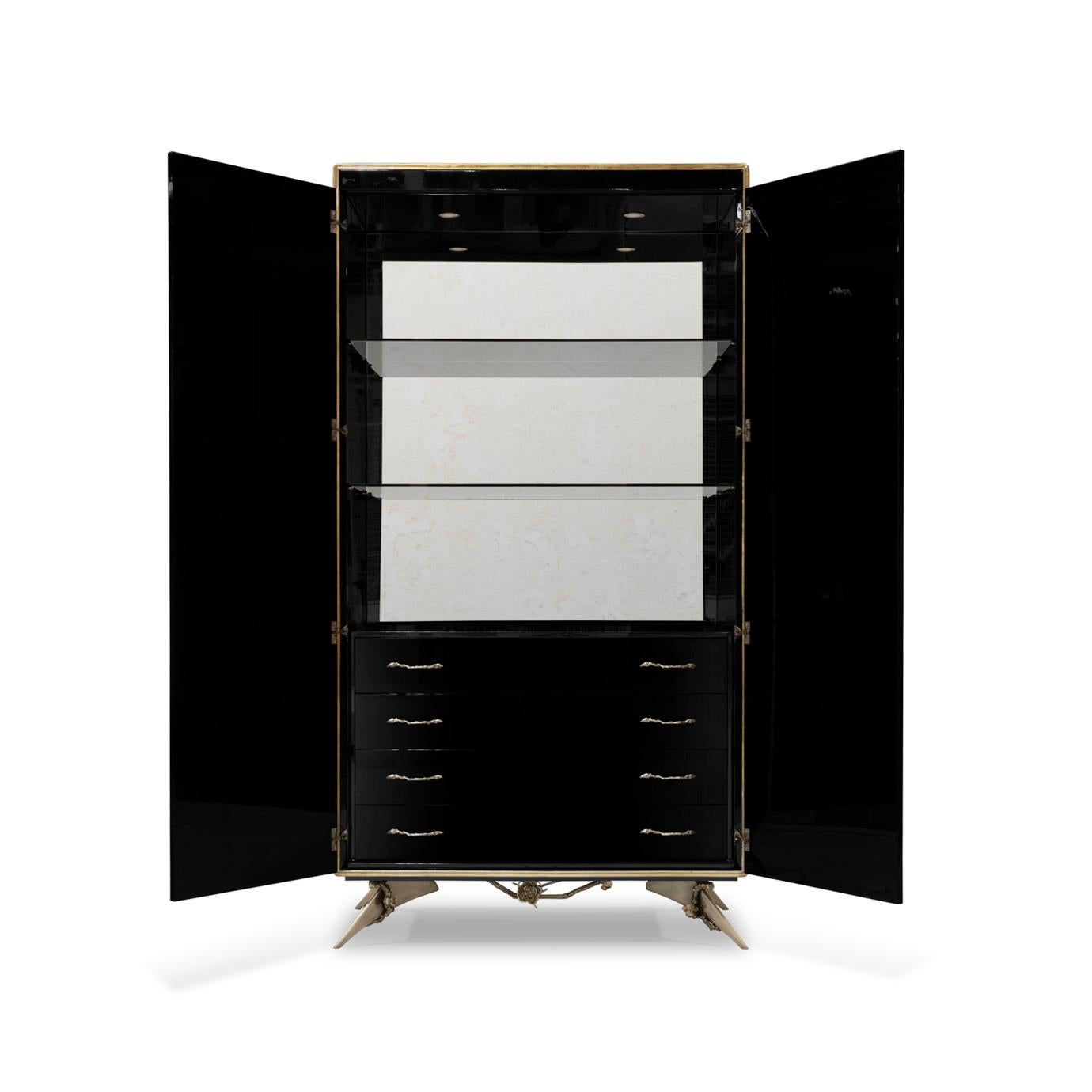 There is a sense of reveal and conceal as KOKET takes a beautiful armoire in high gloss lacquer and adorns it in metal organic lace, revealing a mesmerizing hint of what lies beneath. The stunning interior opens to an antique mirror back with two