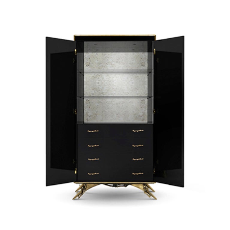 There is a sense of reveal and conceal as Koket takes a beautiful armoire in high gloss lacquer and adorns it in metal organic lace, revealing a mesmerizing hint of what lies beneath. The stunning interior opens to an antique mirror back with two