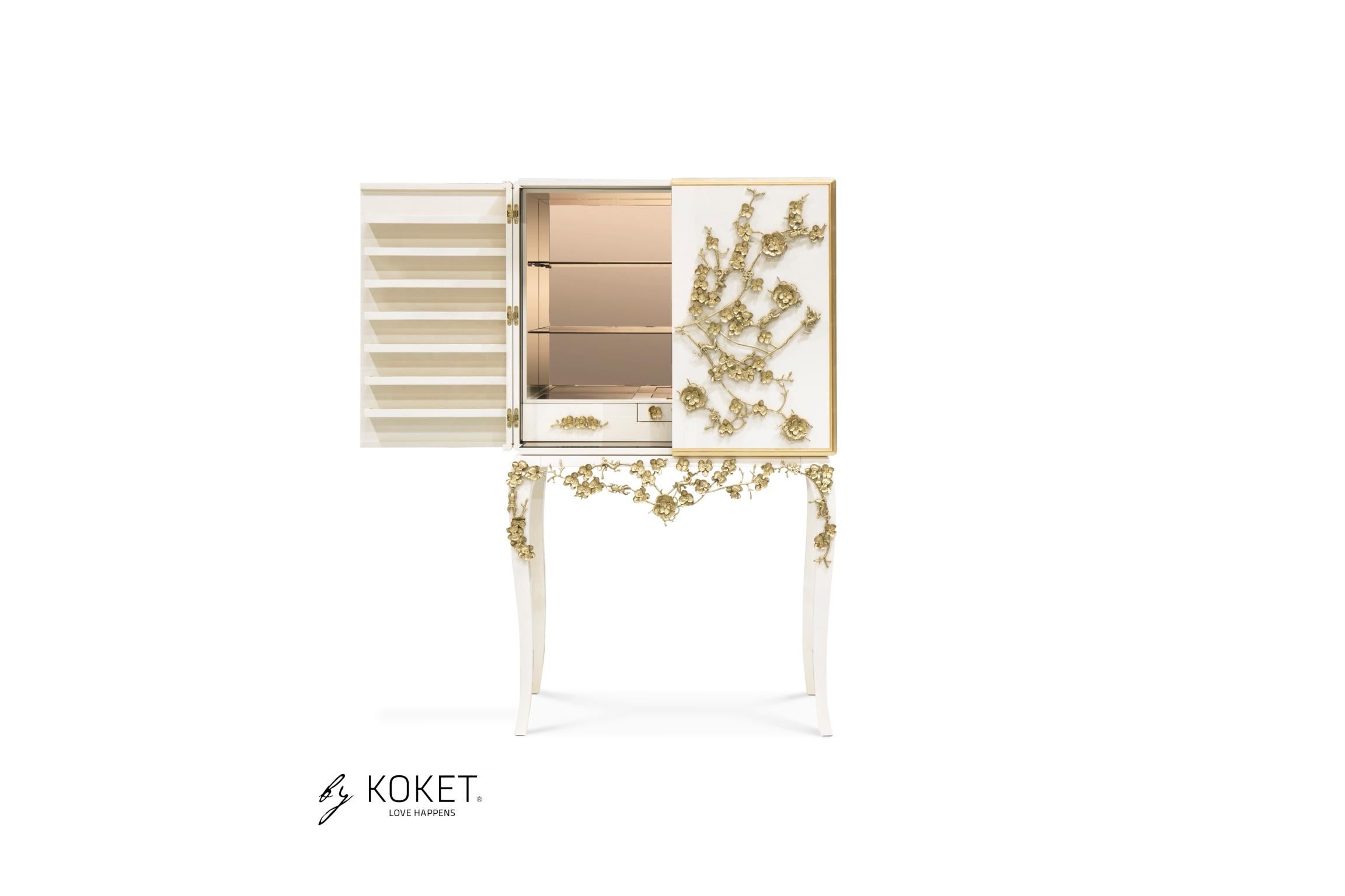 There is a sense of reveal and conceal as KOKET takes a beautiful bar cabinet in high gloss lacquer and adorns it in metal organic lace, revealing a mesmerizing hint of what lies beneath. The chic interior is perfectly designed to store your wine