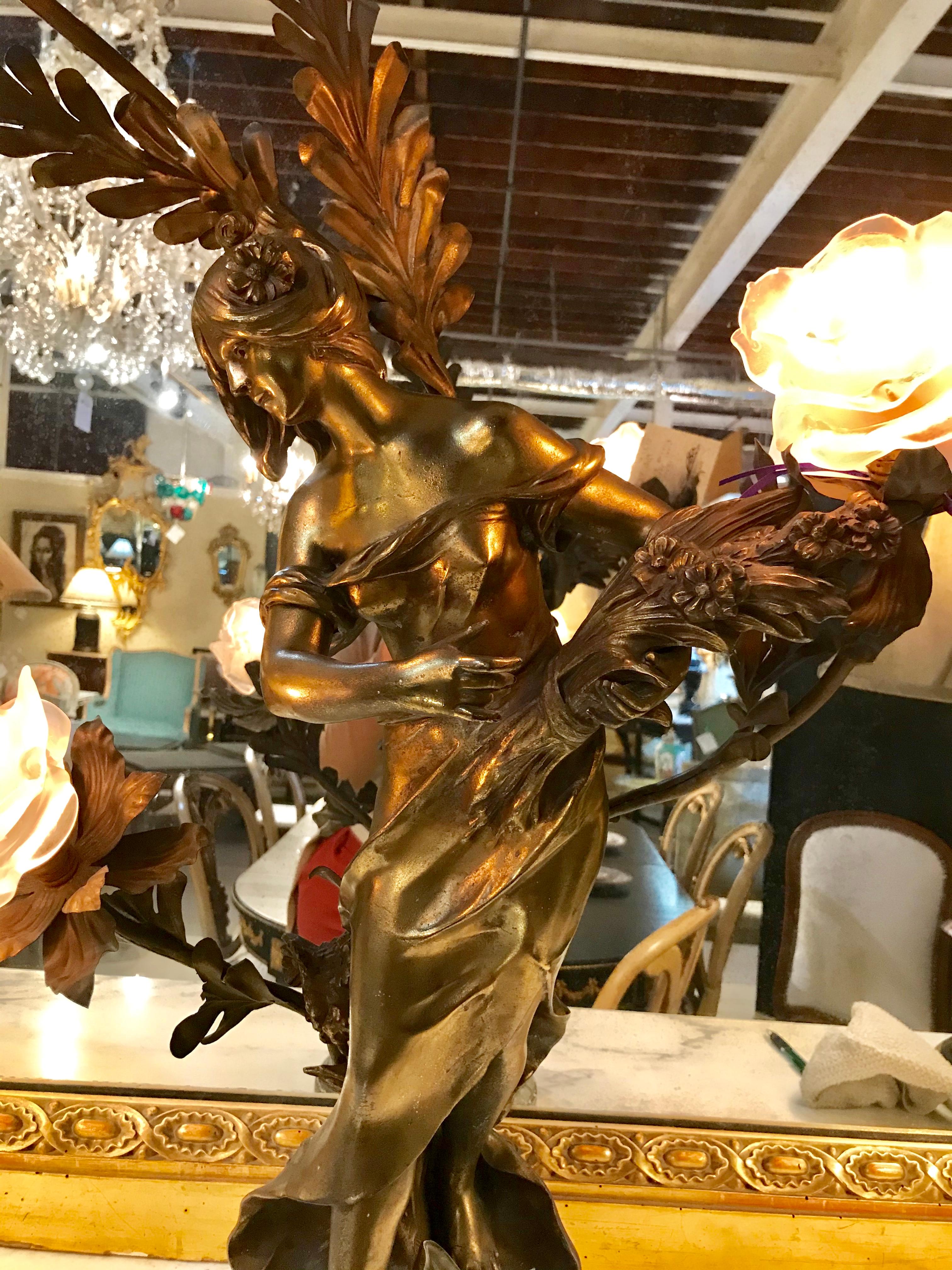 Auguste Moreau French figural table lamp with 3 Lalique style shades. This large and impressive spelter figure of a woman in dress is holding three lights covered by Lalique style frosted globes.