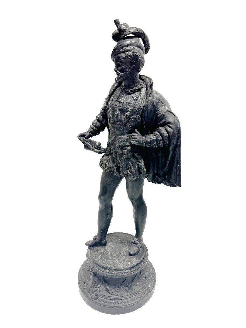 A charming tabletop Spelter Cavalier statue captures the essence of an 18th-century French gentleman, adorned in a flowing cape and distinguished hat. Standing regally, it evokes the grace and grandeur of the era, adding a touch of historical