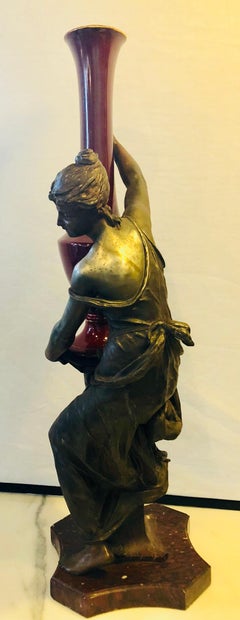 Spelter Figure of a Water Bearer on a Pedestal / Marble with Red Glazed Vase
