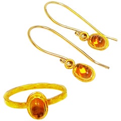 Anello e orecchini pendenti in oro 22 carati con granato spessartino