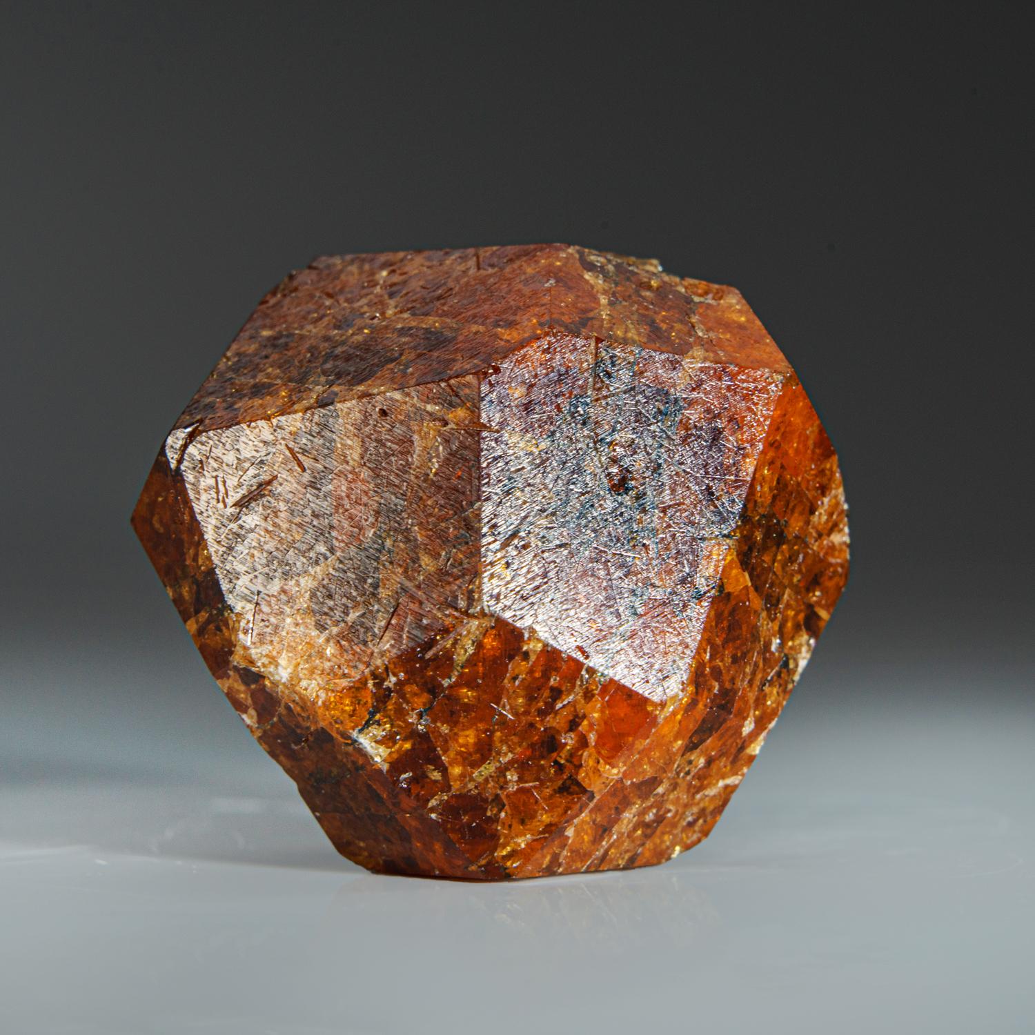 Da Nani Hill, Loliondo, distretto di Ngorongoro, Arusha, Tanzania Grande cristallo trapezoidale di granato spessartino arancione trasparente senza matrice. Ha facce lucide con bordi ben definiti. Questa gemma presenta una vibrante tonalità arancione