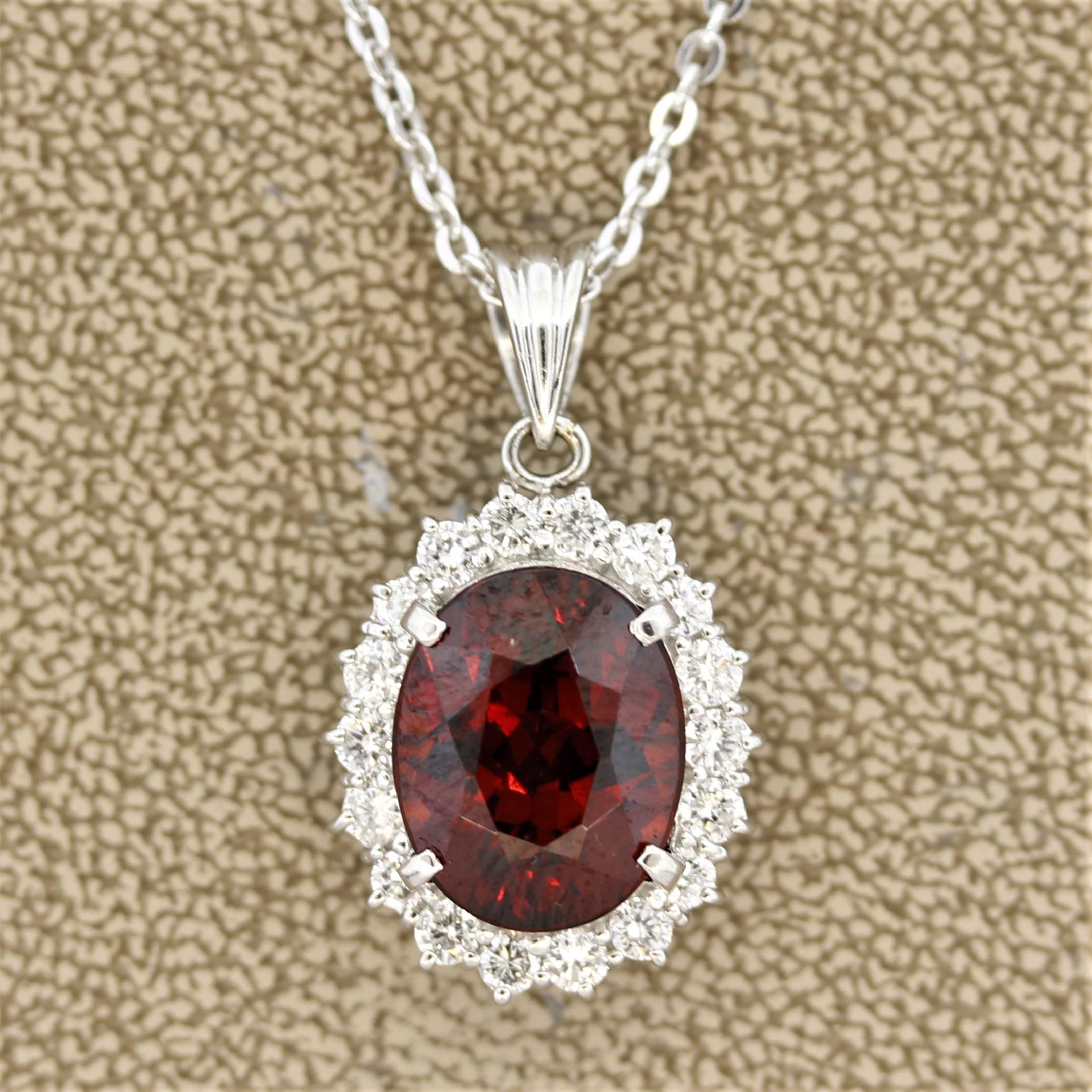 A lovely pendant featuring a fine orange-red spessartine garnet. It has an intense color with excellent brilliance and weighs 9.46 carats. Accenting the garnet is a halo of round brilliant cut diamonds weighing 0.96 carats. Hand-fabricated in