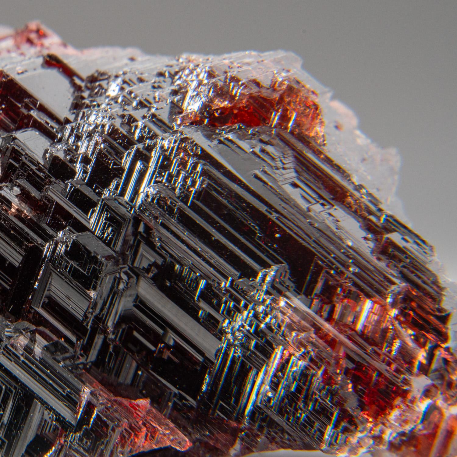 From Lavra Navegadora, Penha do Norte, Minas Gerais, Brazil

Lustrous transparent dark-red spessartine garnet crystal with irregular crystal form and surfaces composed of many parallel, stepped faces on all sides. The spessartine garnet is fully