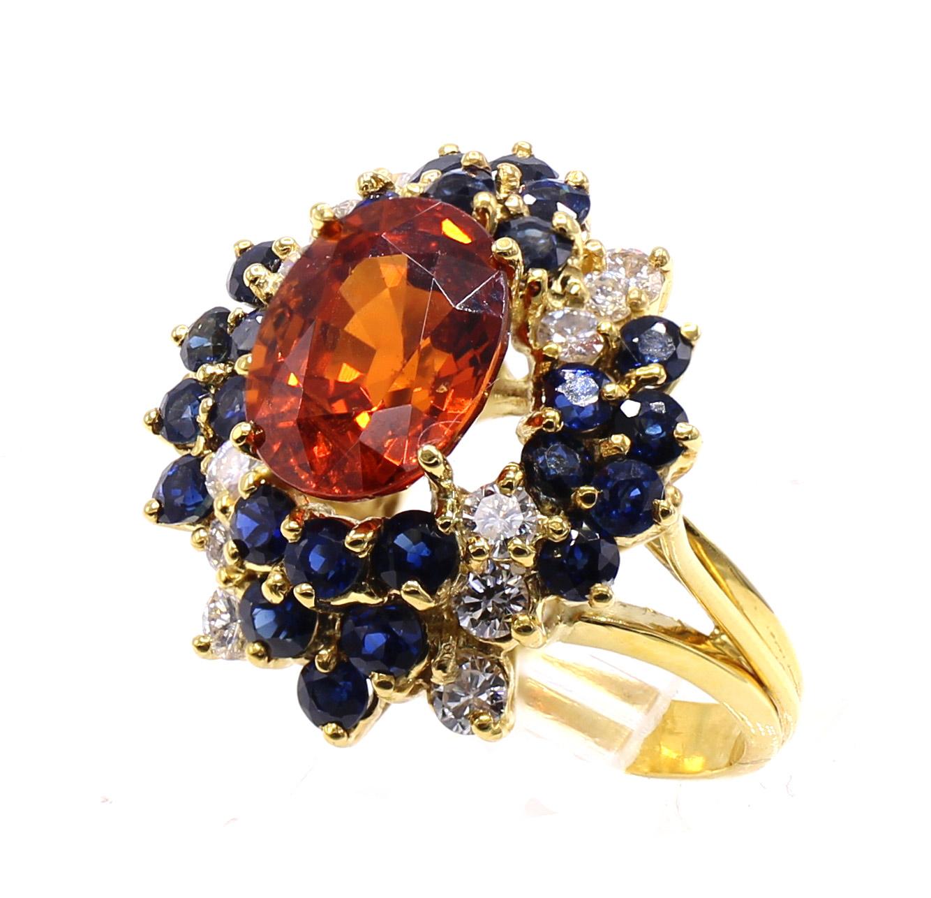 La pièce centrale de cette bague des années 1970 magnifiquement conçue et fabriquée à la main est un grenat spessartine de couleur orange vif pesant 5,86 carats. Cette pierre précieuse peut également être classée dans la catégorie des grenats