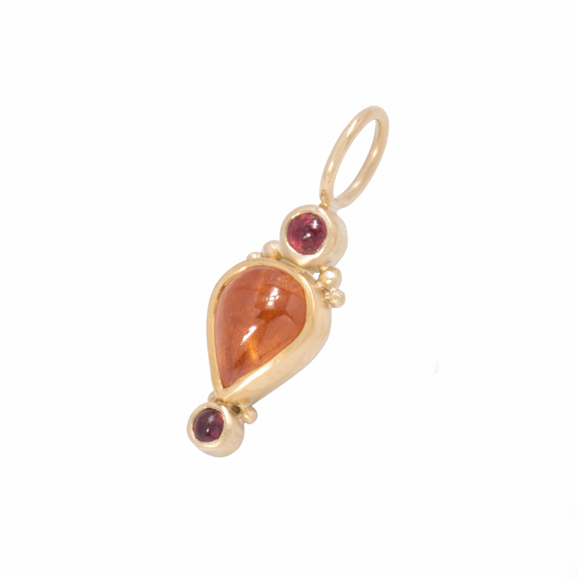 A honey colored, pear shaped spessartine garnet cabochon 5.69cts is bezel set in 22 karat gold in the Turkish Pear Pendant. Topped and tailed with deep red spinel cabochons .83ctw, the Turkish Pear Pendant is beaded at the crown and set with a very