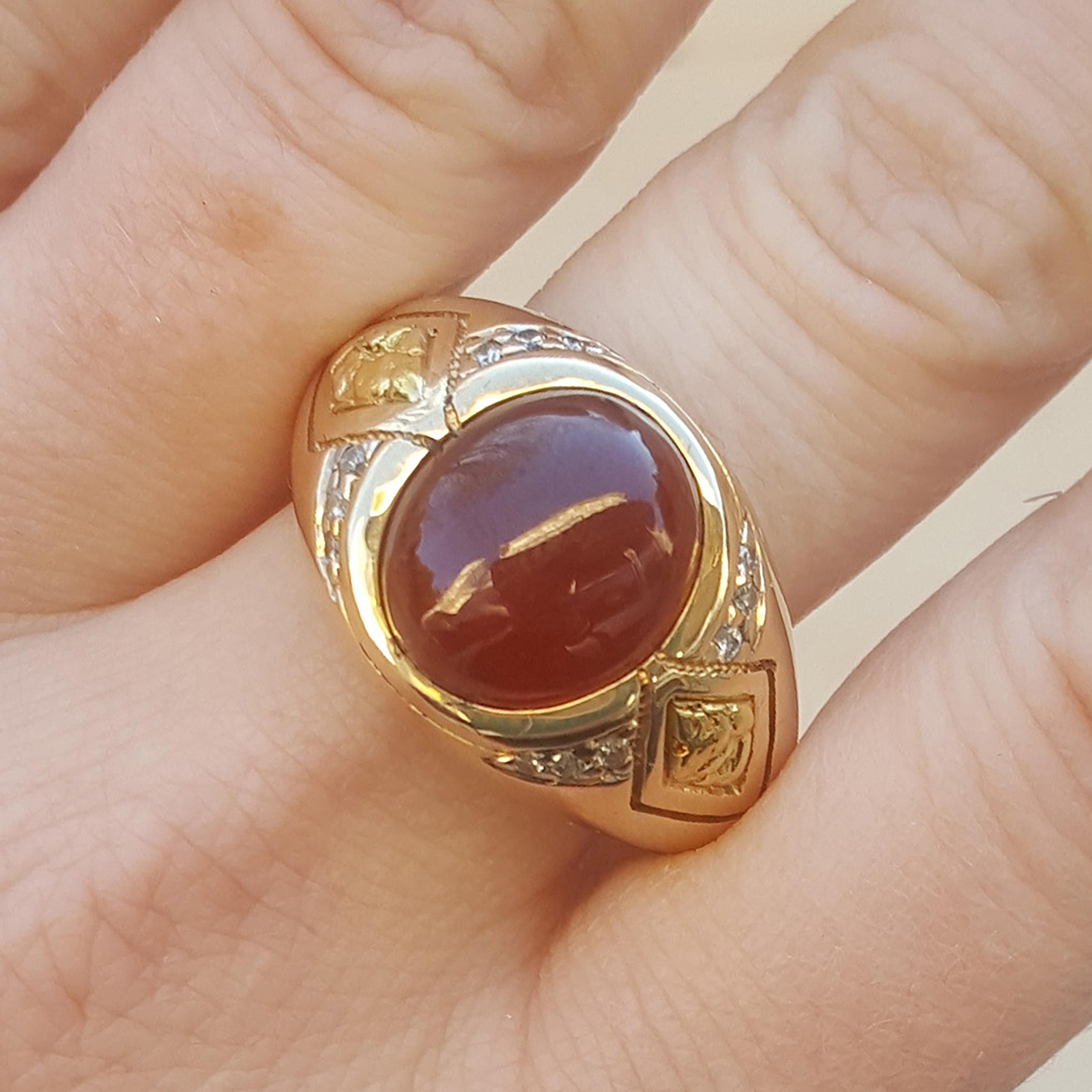 This rare type of spessartite garnet, in a deep shade of spicy orangey-red, is the perfect centerpiece for this classic men’s 14kt ring. The smoothly polished 9.25ct cab contrasts nicely with the texture added by 0.17ct of fine diamonds and