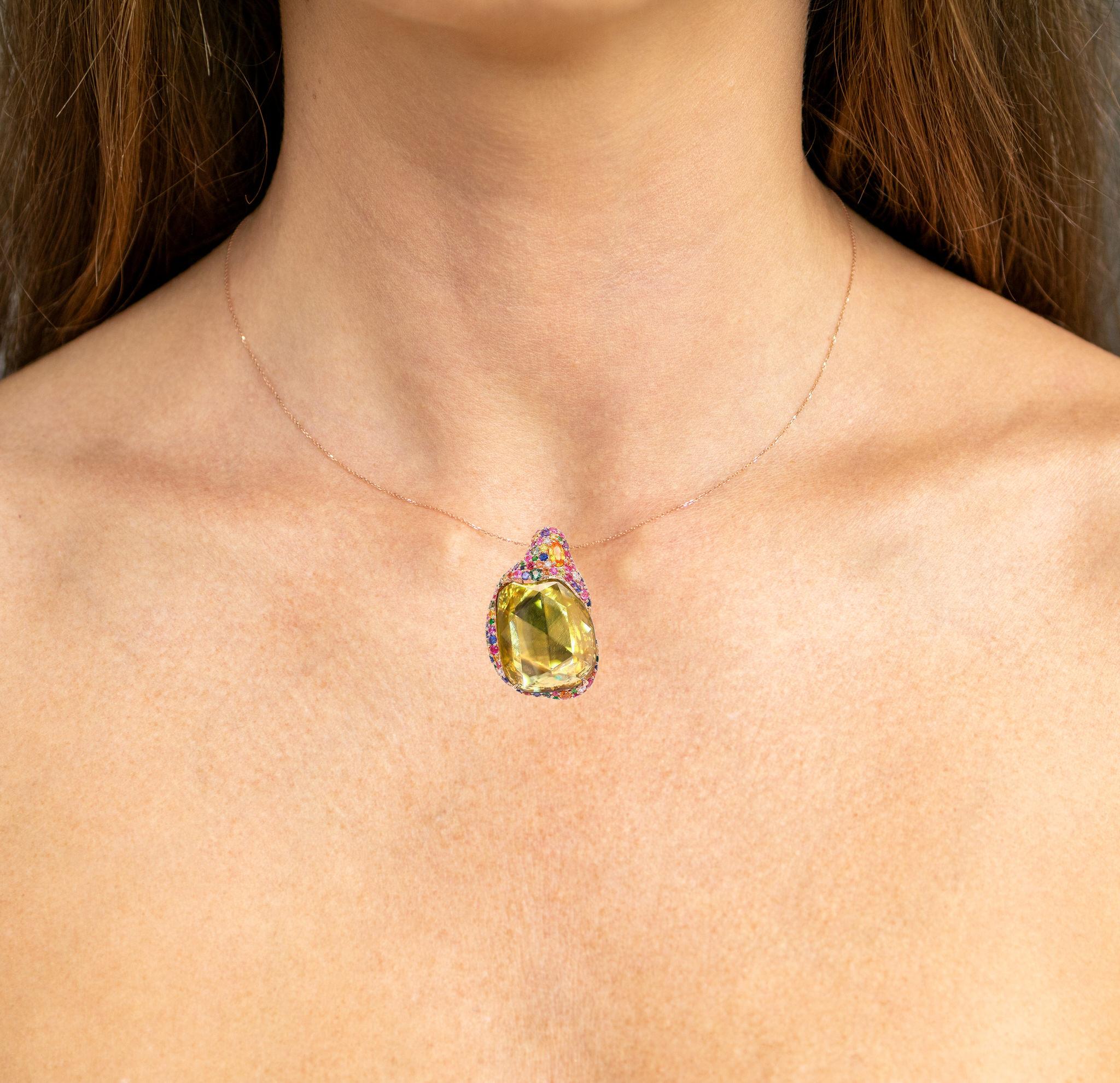 Il est accompagné d'une évaluation gemmologique par la GIA (GG/AJP).
Toutes les pierres précieuses sont naturelles.
Sphène = 14,95 Carats
109 saphirs fantaisie = 2,18 carats
5 diamants = 0,10 carats
Métal : Or rose 18K
Dimensions : 36 x 23 x 5 mm :