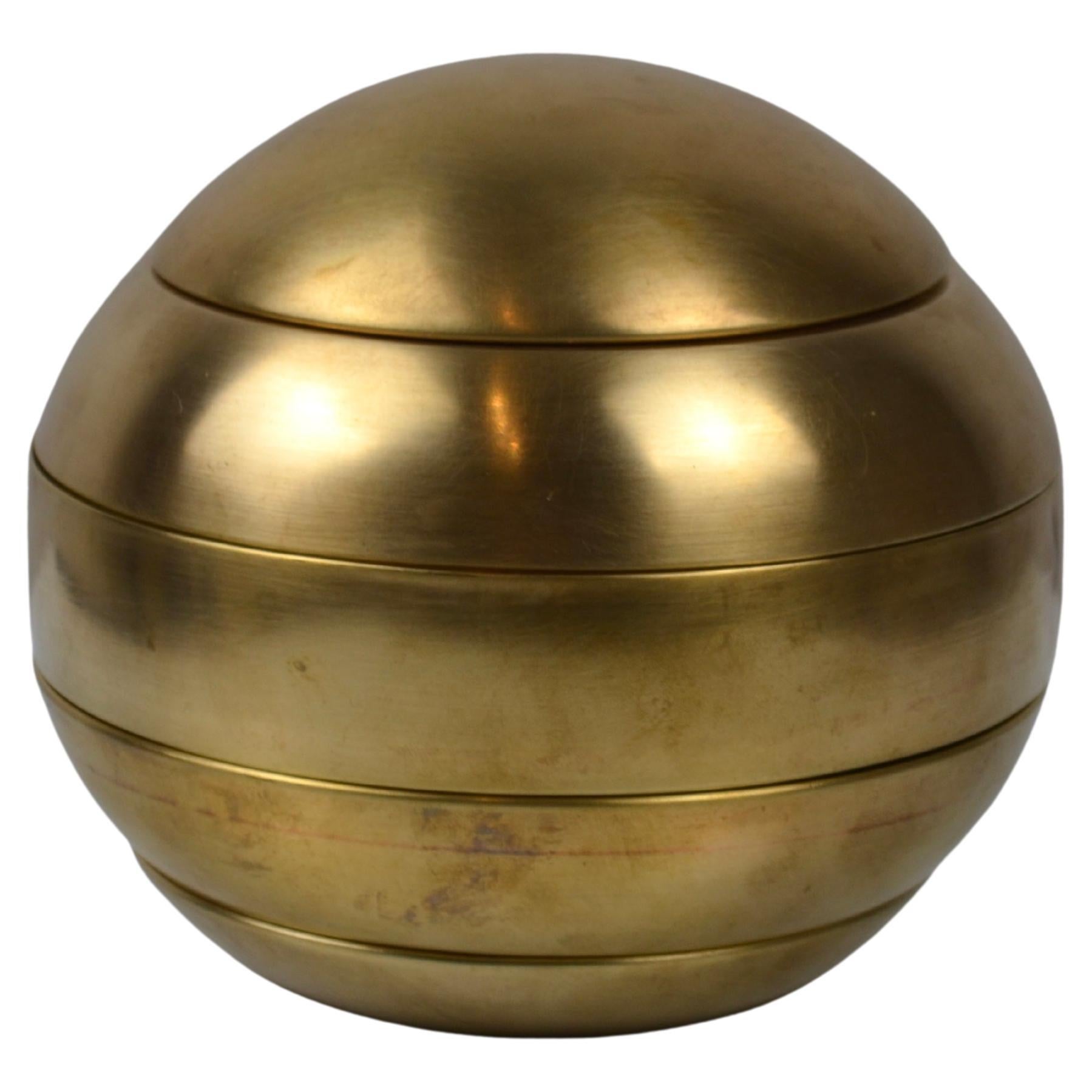 Elegant et rare ensemble de cinq cendriers empilés en laiton conçus par le designer italien Tommaso Barbi dans les années 1970.
Les cinq éléments modulaires s'empilent pour former une sphère sculpturale en laiton, caractéristique de l'esthétique