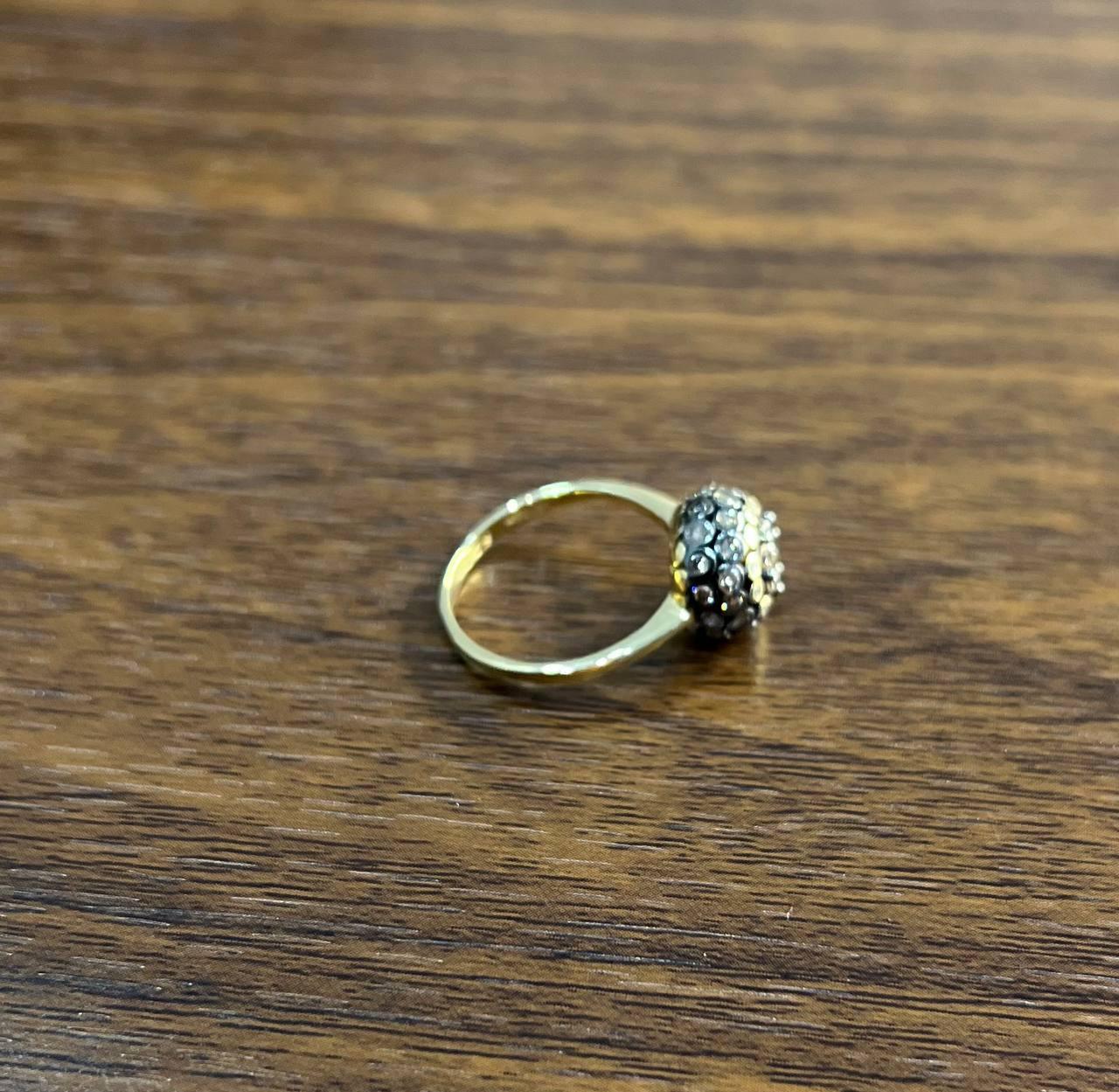 Eine Studie über Form, Textur und Schimmer.

Dieser auffällige Ring hat ein kühnes, kugelförmiges Design, das mit einer Vielzahl von funkelnden Diamanten besetzt ist. Das komplizierte Arrangement erzeugt ein fesselndes Spiel von Licht und Schatten,