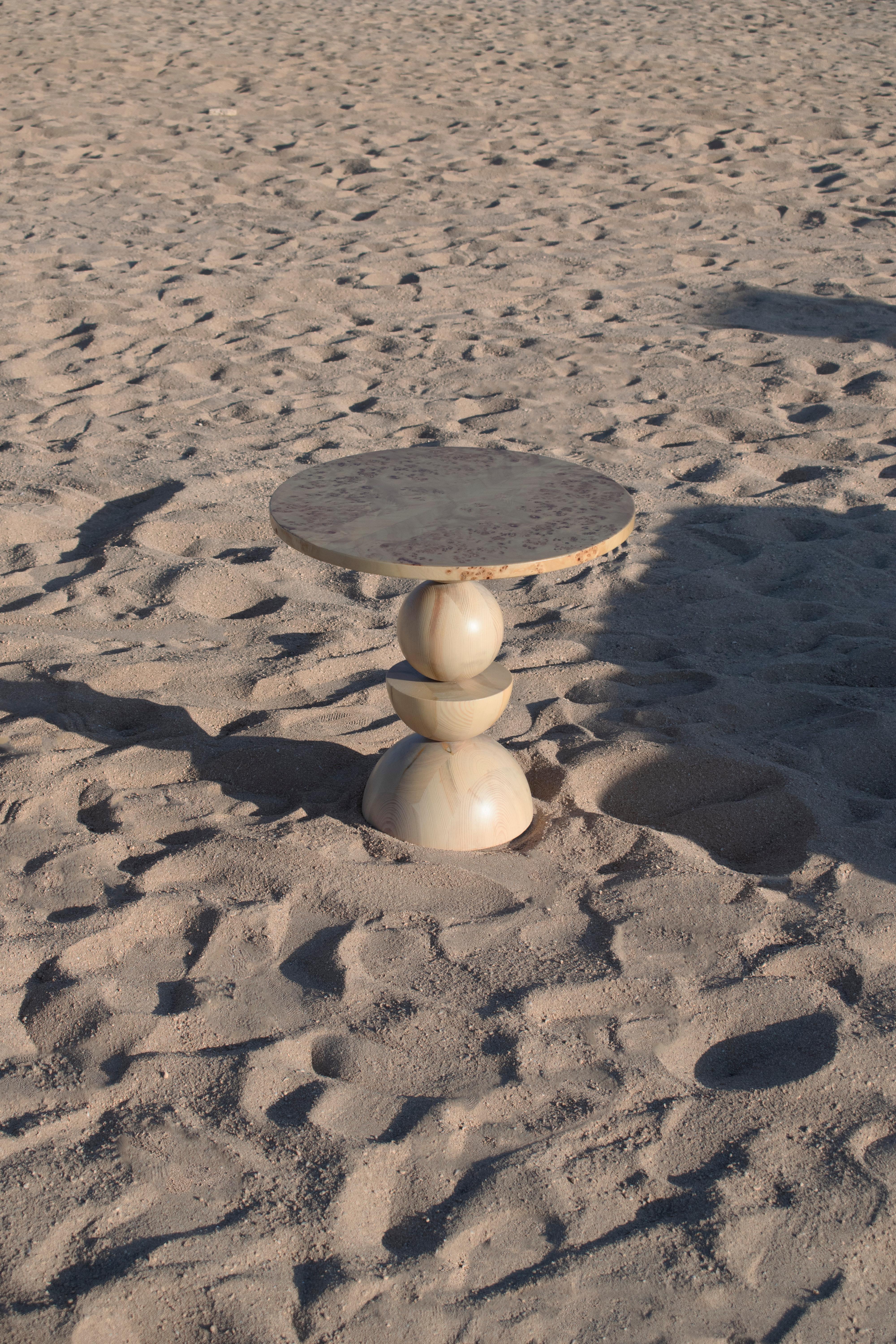 Plateau en loupe d'érable et demi-sphères et sphères complètes en bois massif de pin suédois, laqués mats en transparence.

Explorant l'idée d'un arrangement vertical des prismes classiques utilisés dans la collection, cette pièce prend la forme