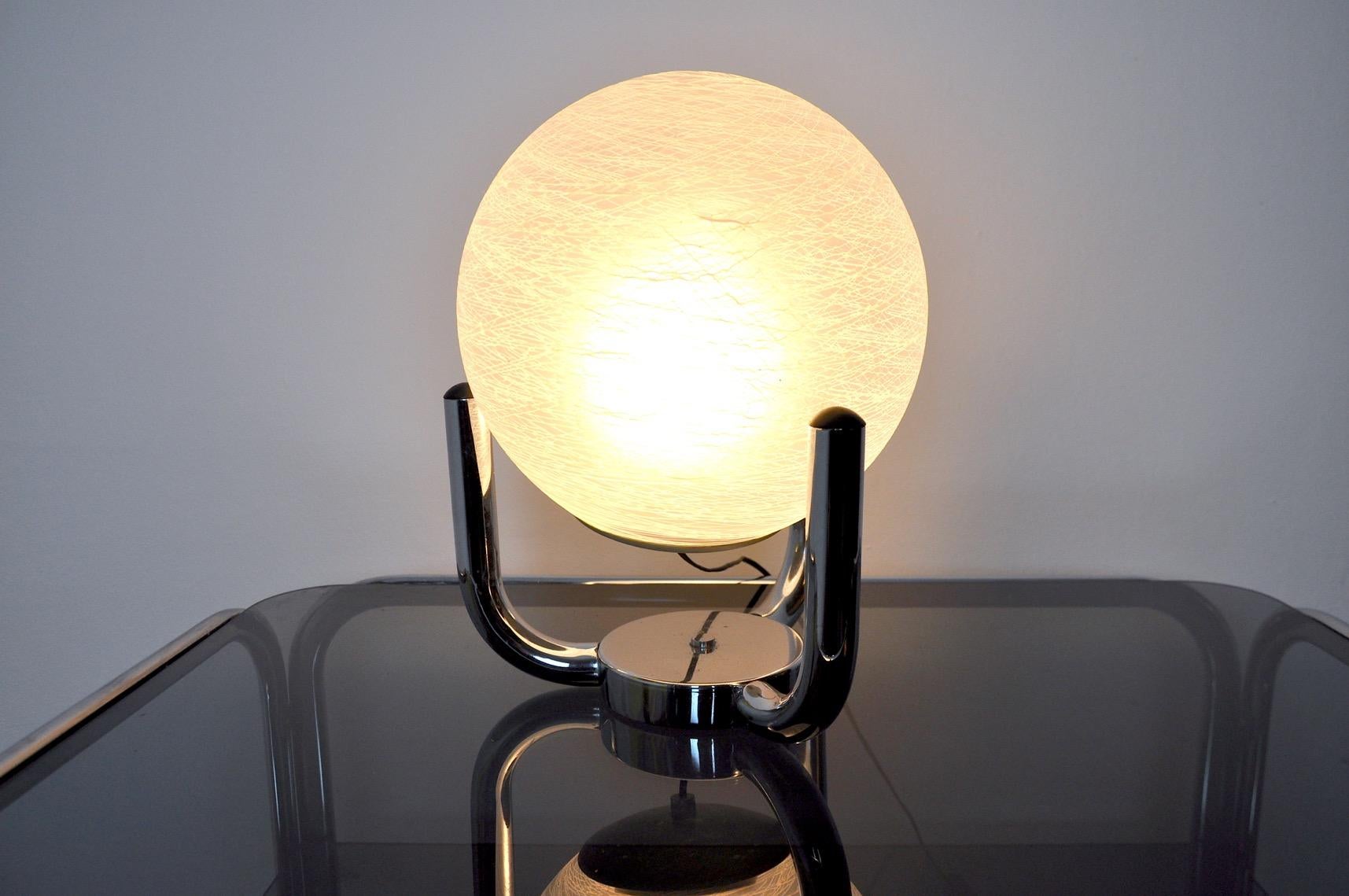 Very beautiful table lamp from the Sciolari house, designed and produced in Italy in the 1970s. Its chrome base separates and has a frosted murano crystal globe. This uniquely designed object will perfectly illuminate your interior. Electricity