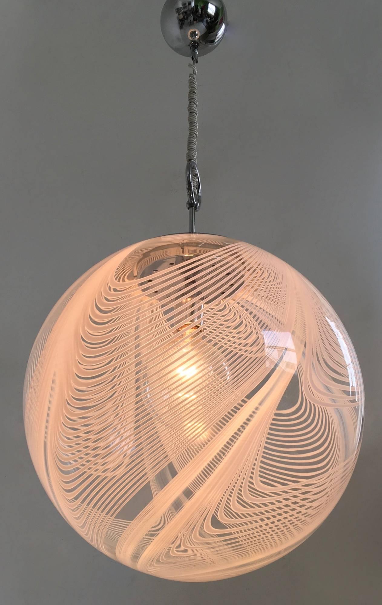Made in Italy.
In Murano blown glass and chrome-plated metal. 
Its glass globe features smaller and larger swirled lines that create a beautiful pattern on the wall when turned on.
In perfect original condition and ready to give ambiance to any
