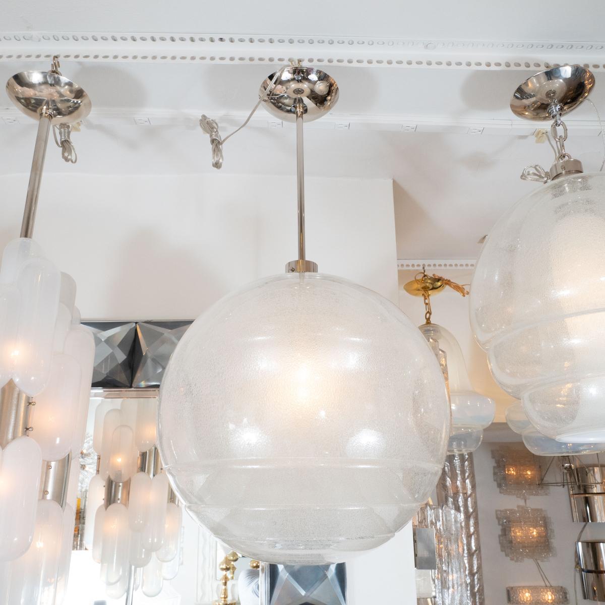 Spherical, glass pendant featuring multiple, tapered glass cores with inclusive air bubbles by Carlo Nason for Mazzega.