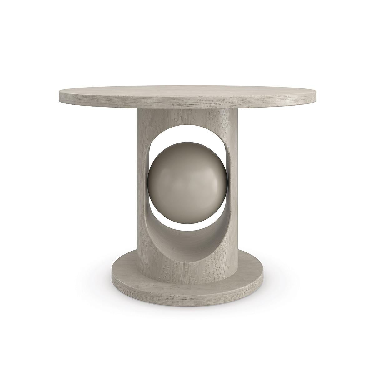 Naturally evoking a sense of balance, this eye-catching dining table features a decorative sphere suspended within its curved pedestal base. A light taupe finish highlights the organic beauty of ash and oak wood for a timeless neutral hue that