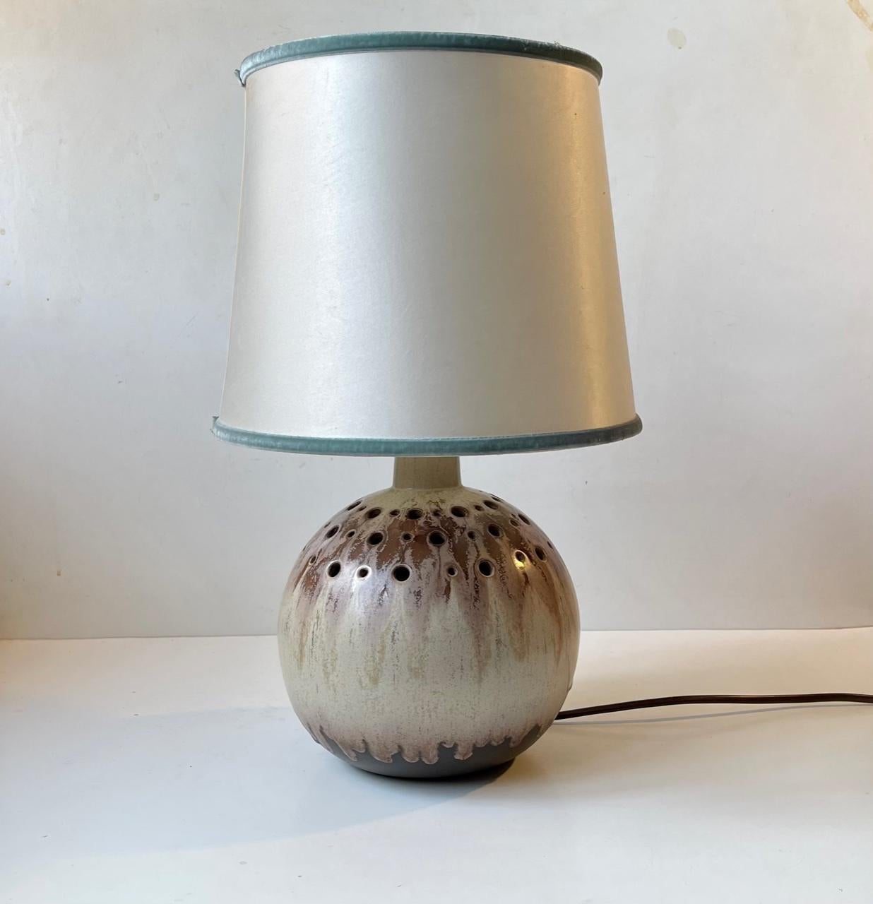 Large Spherical ceramic table light decorated with earthy drip glazes. The light features a partially perforated corpus, shade holder and on/of switch to the cord. It was made in Denmark during the 1970s. The base is signed by an unidentified