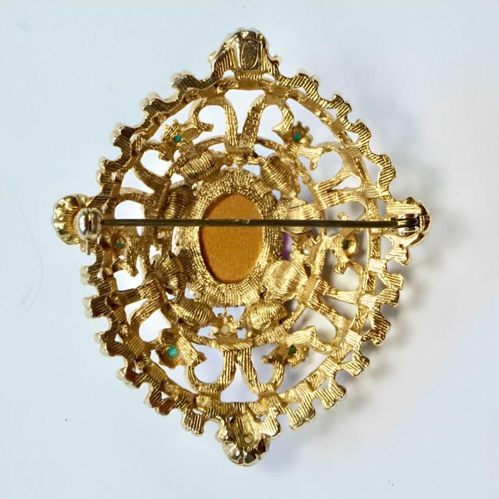 Merveilleuse broche de style Renaissance en plaqué or, ornée de fausses perles, de fausses turquoises, de faux grenats et d'un joli cabochon central en verre mauve. Longueur 5,9 cm / 2,32 pouces et largeur 5 cm / 1,9 pouces.

Cette jolie broche de