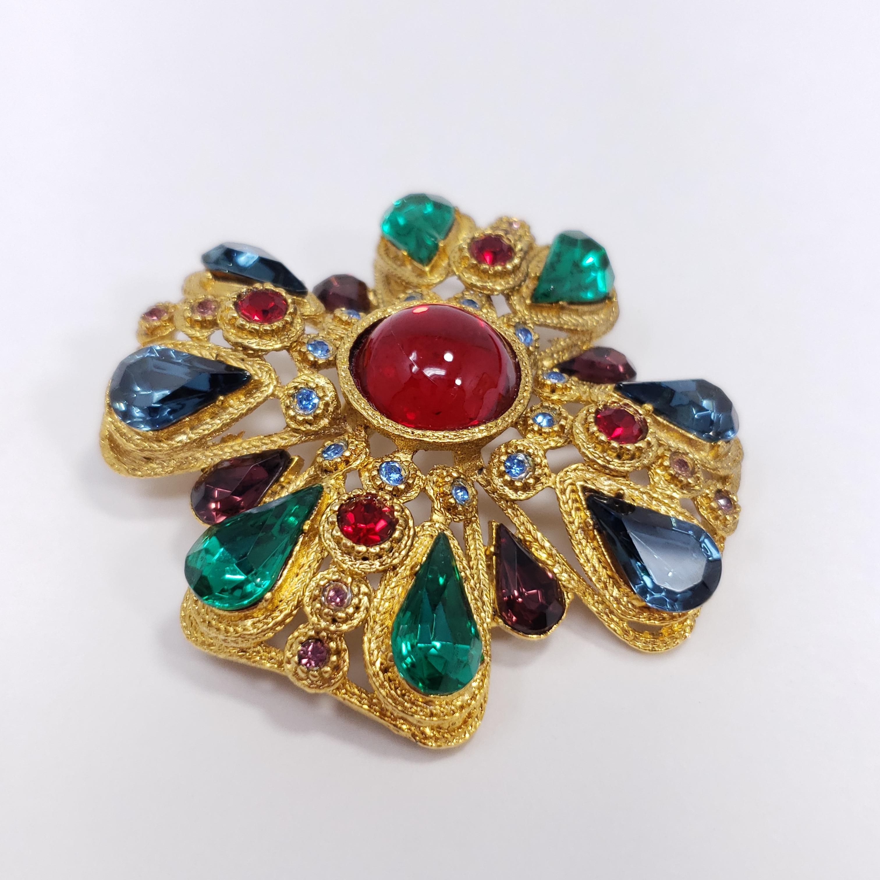 This glamorous 20th century Maltese cross pin is decorated with ruby, aquamarine, and topaz cabochons & emerald crystals. For a sophisticated and stylish look!

Gold-plated. Made by Sphinx.

Marks / hallmarks / etc: 9242