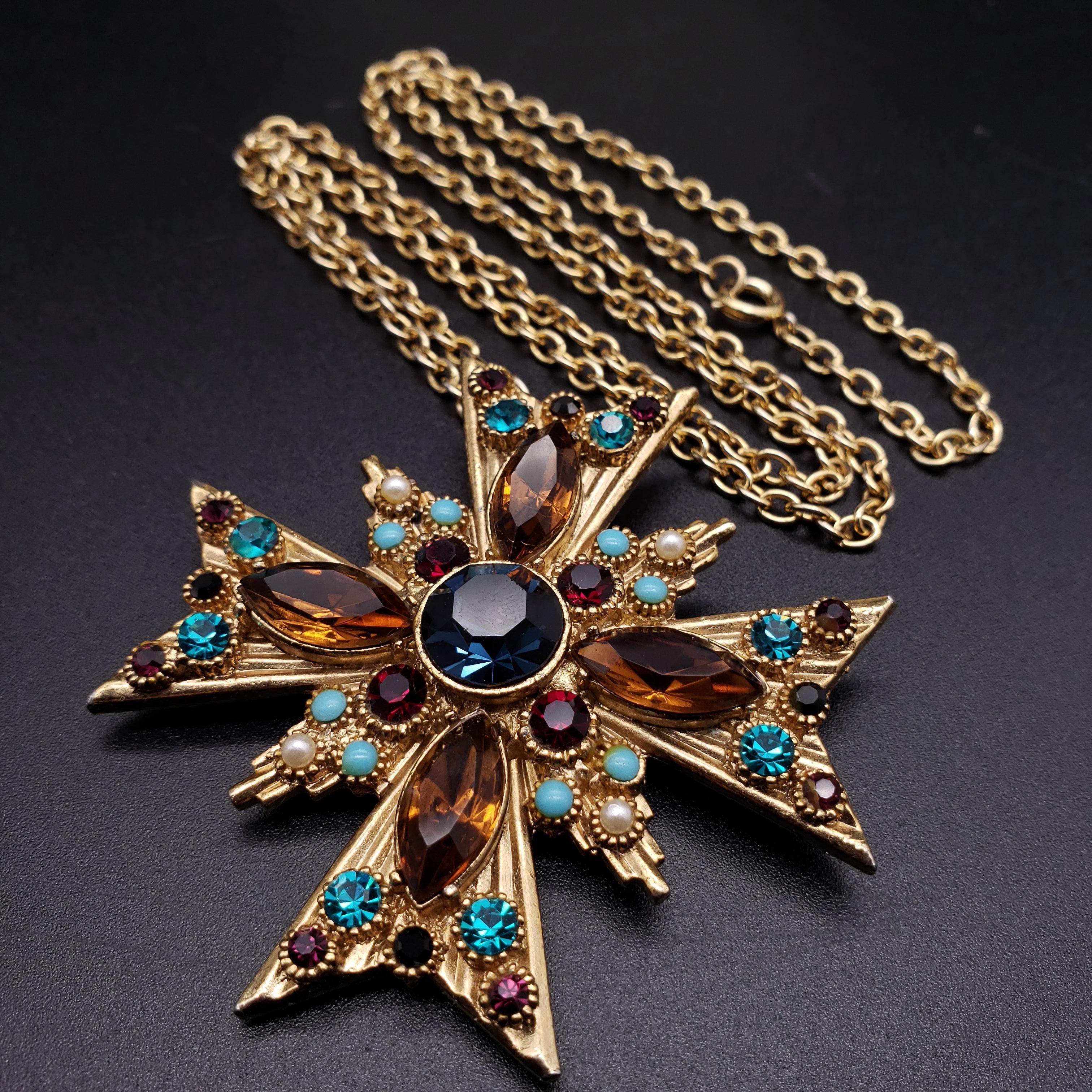 This glamorous 20th century Maltese cross pin pendant chain necklace is decorated with ruby, aquamarine, and topaz emerald crystals. 
For a sophisticated and stylish look!
There's some metal wear on the pendant bail.
Gold-plated. Made by