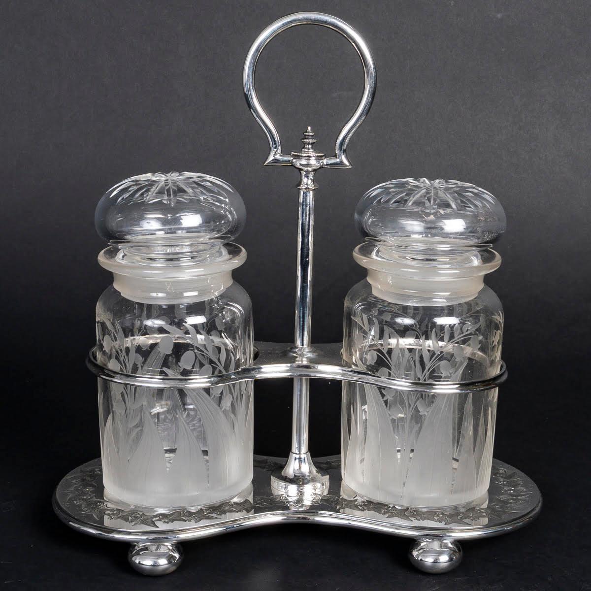 Service à épices en métal argenté et cristal, 19e siècle.

Service à épices d'époque Napoléon III avec ses deux pots couverts, 19e siècle, en cristal et métal argenté.
H : 23cm, L : 24cm, P : 12cm