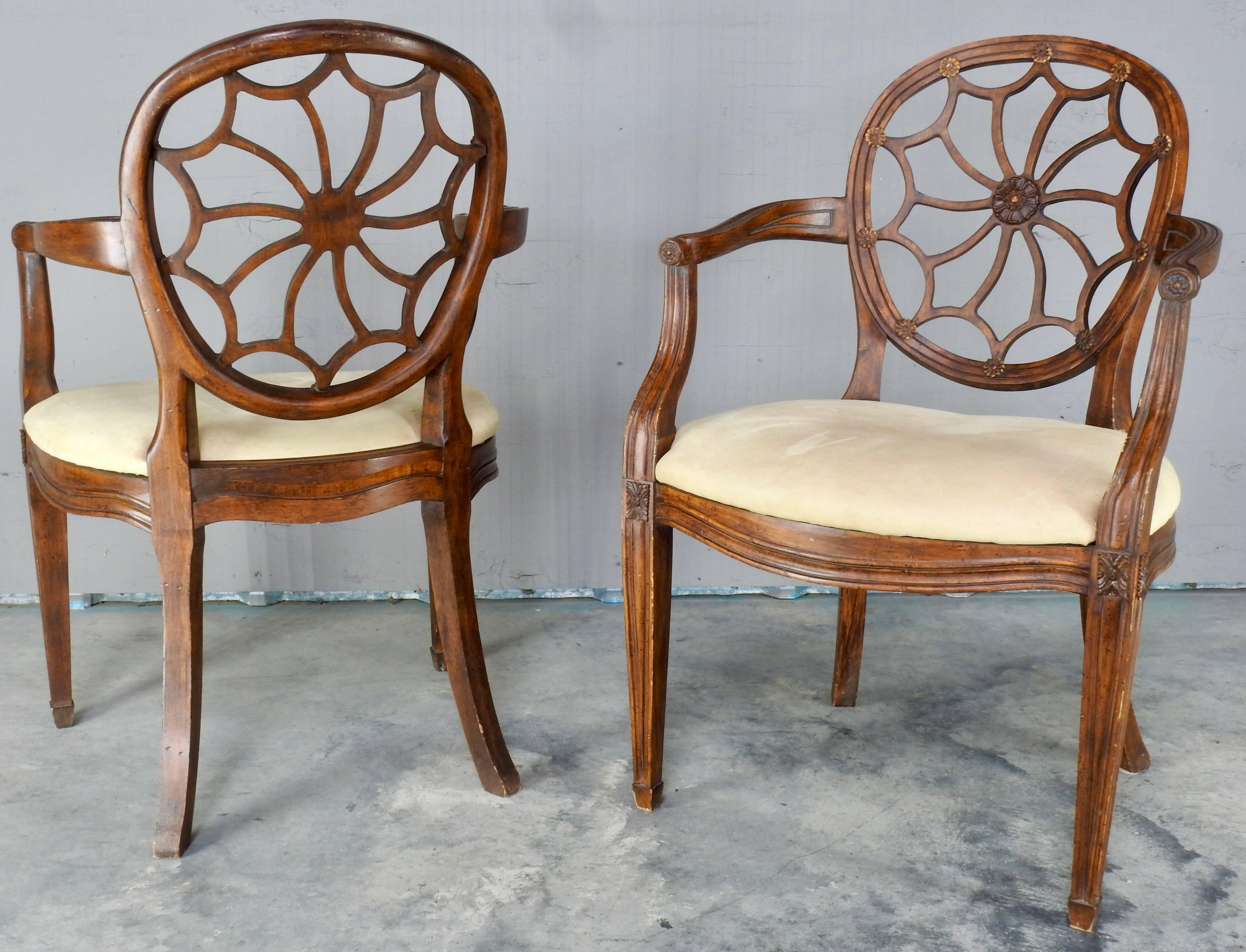 We are offering a pair of elegant spider back Hepplewhite style chairs from the early 20th century. The centre of the web has nicely carved details in a floral pattern and that floral pattern is repeated at the end of each curve where the back meets