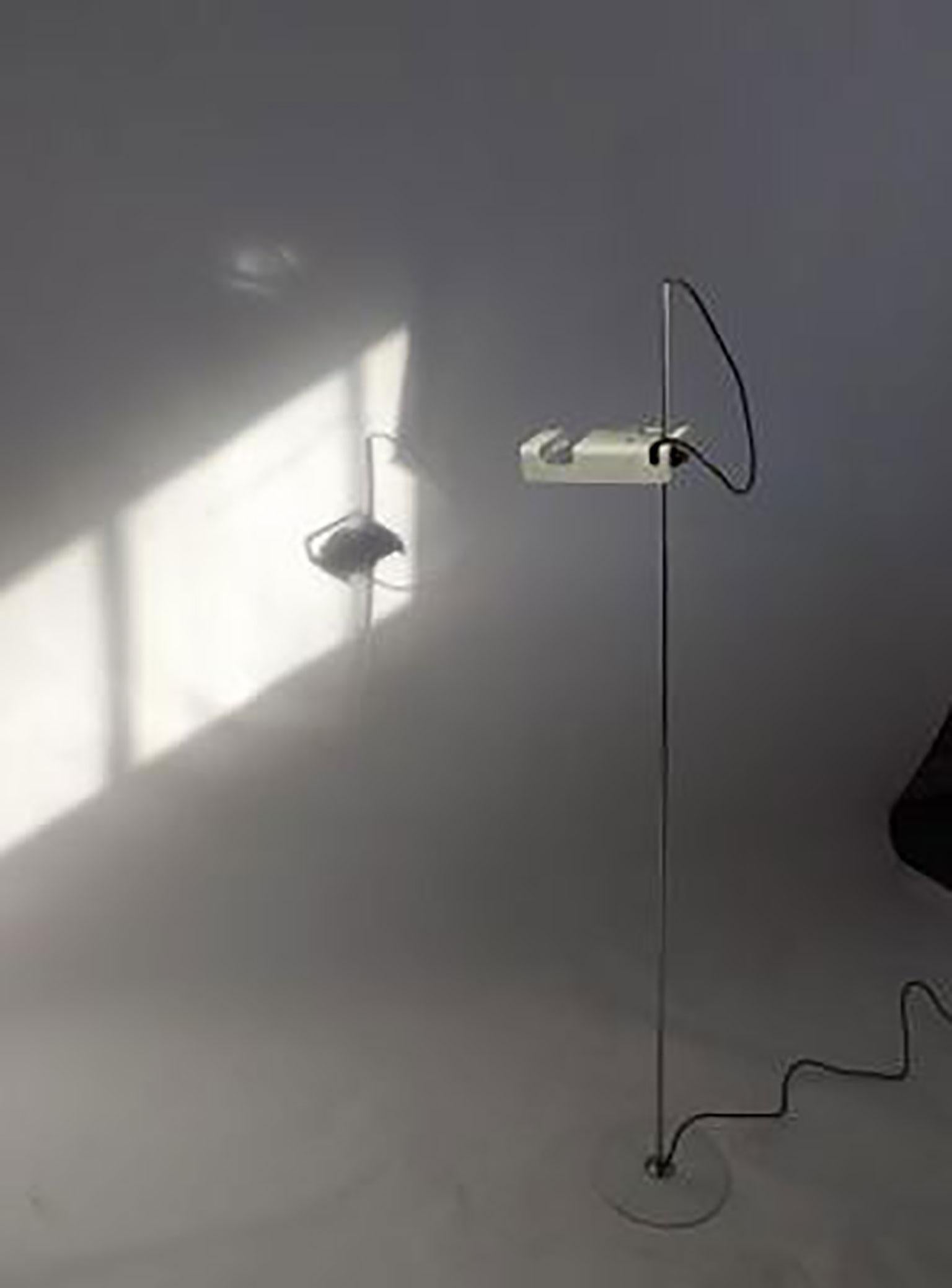 Spider floor lamp by Joe Colombo for Oluce. This minimalistic light fixture features a unique design with the head of the lamp connected to the stem by a plastic joint that is responsible for tilting the lamp side-to-side. The lamp produces a direct
