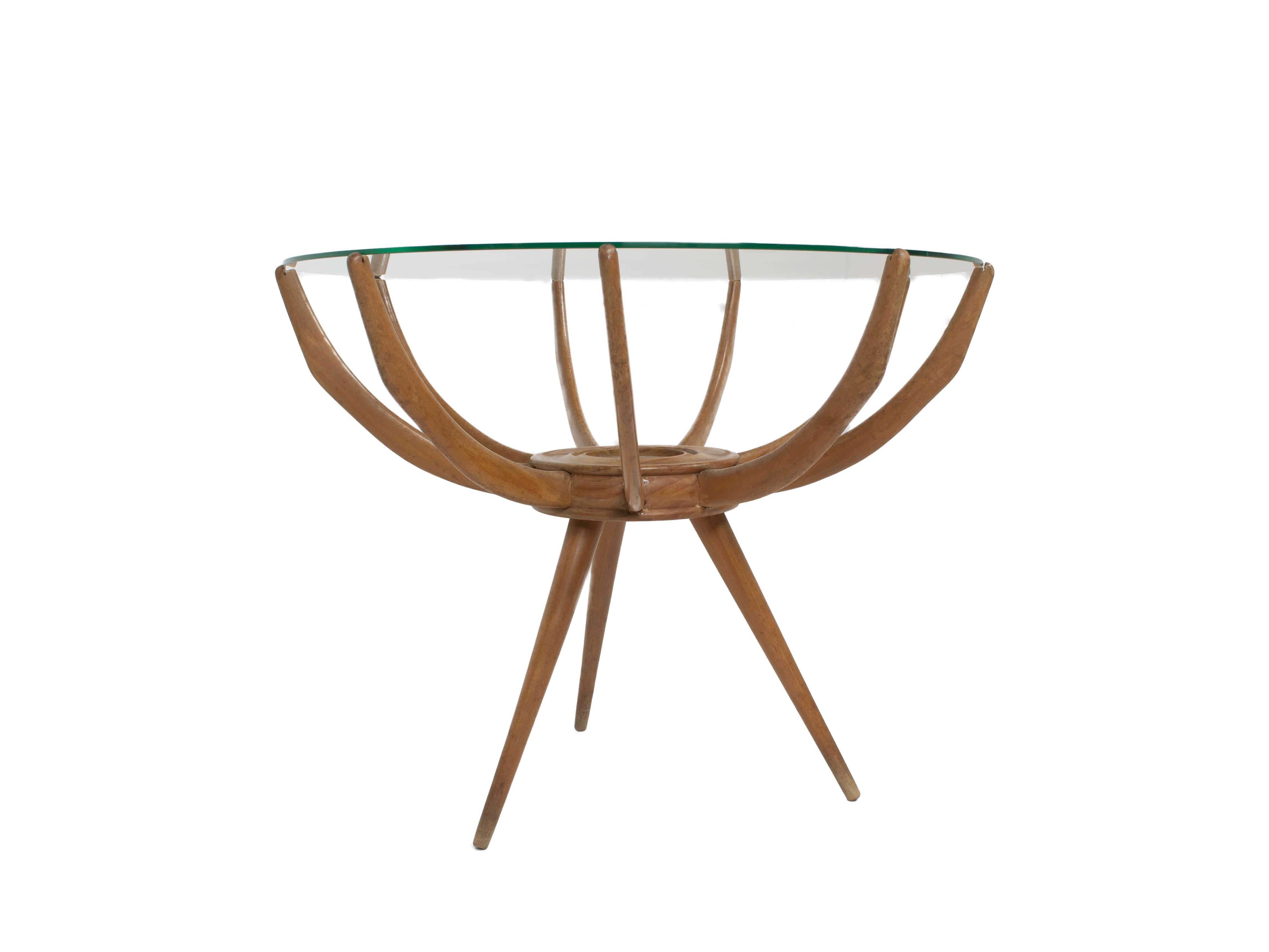 Nice spider leg coffee table by Carlo di Carli, Italy 1950s. This iconic table has three legs and nine wooden 'arms' to keep the glass top steady. The structure of the table reminds of inset legs, therefore the name 'Ragno' or Spider Table. The