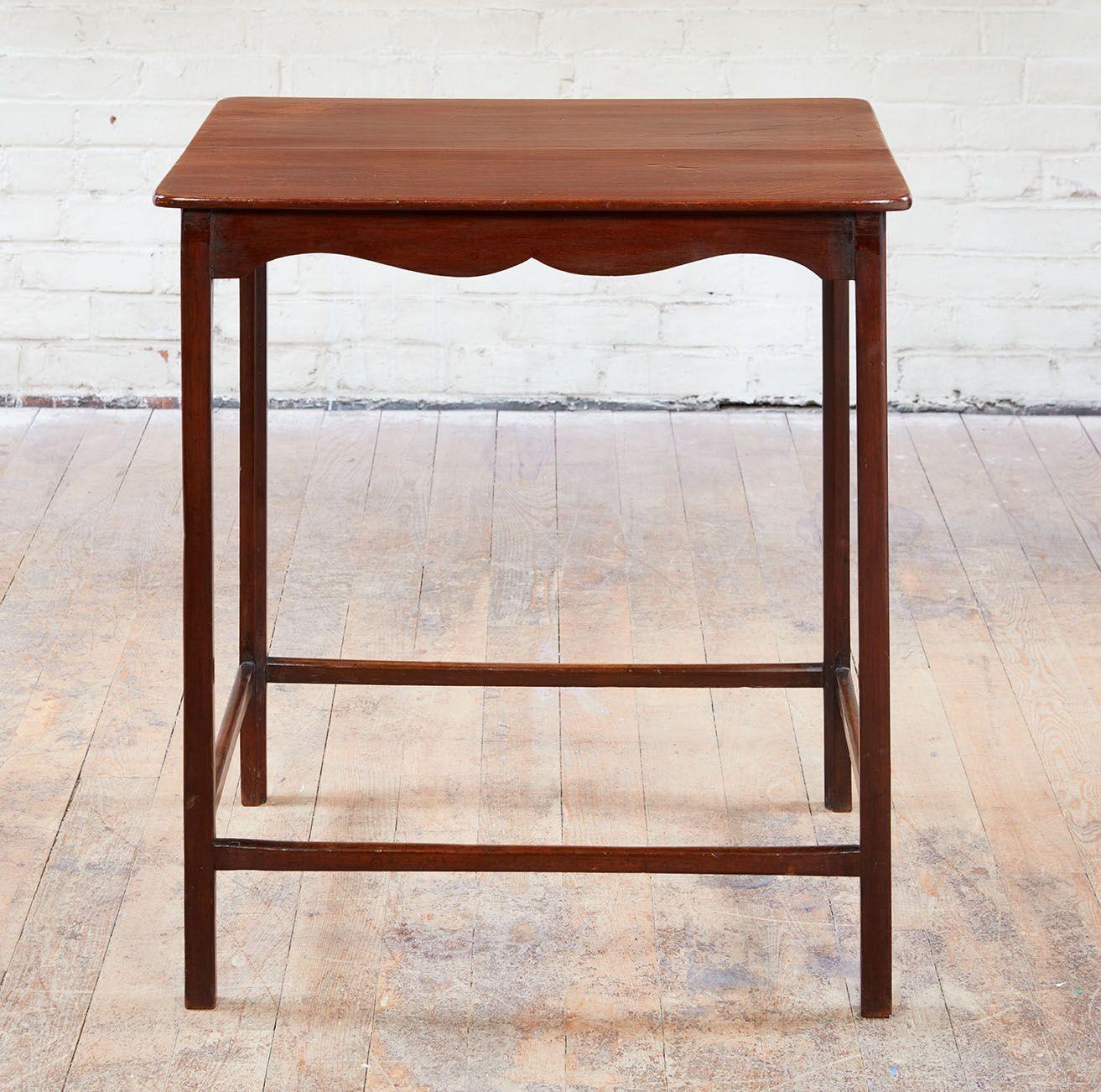 A late 18th century spider leg table, featuring a thin single piece top over a shaped apron to all sides, standing on very slender square section legs united by a continuous box stretcher. Constructed of well patinated mahogany and possessing an