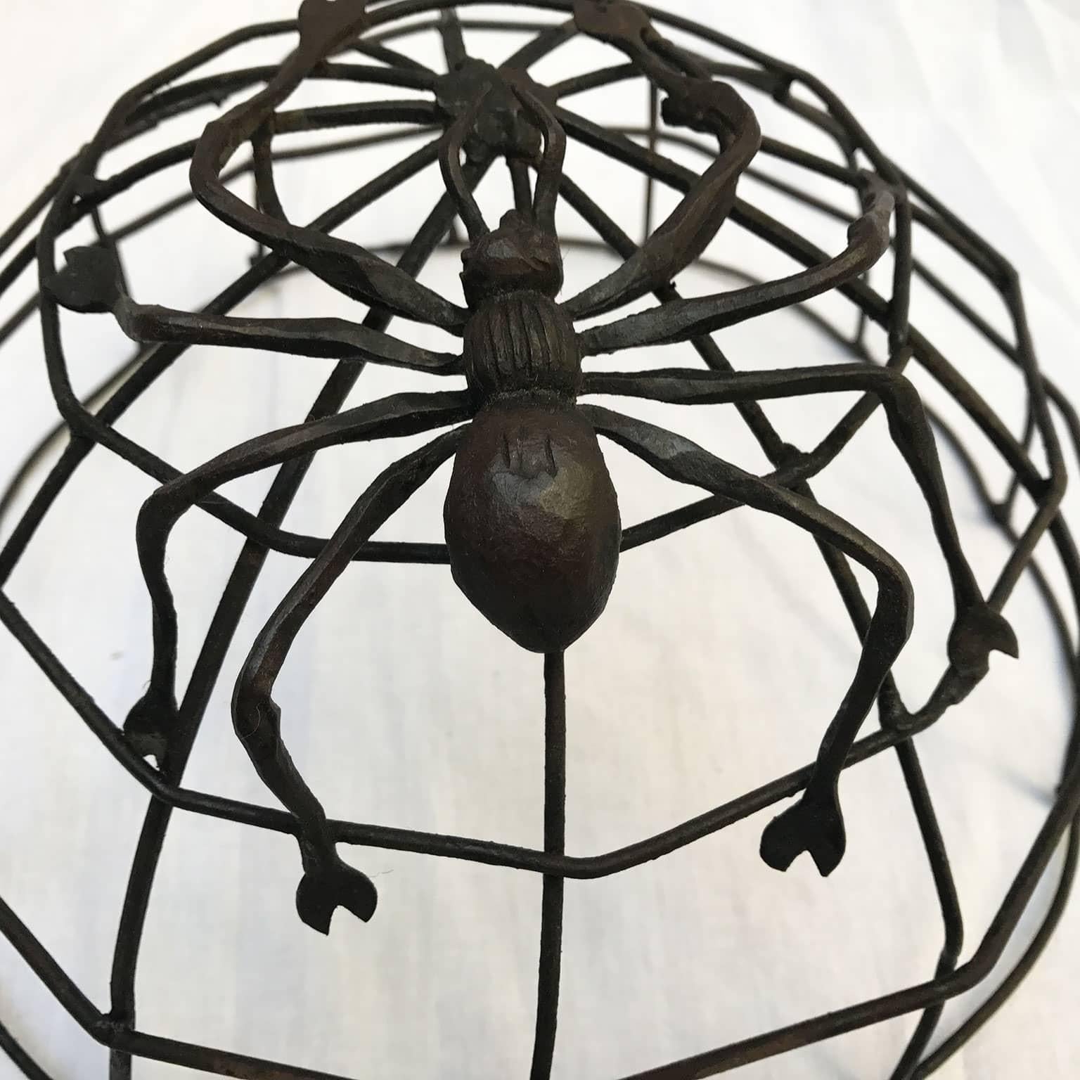 Italian one-light wrought iron cobweb and spider ceiling lamp with a single Edison 27 bulb light; a very unusual handmade light, a circular leafy garland with a spider web shaped ceiling fixture. It may be hanged to the ceiling or fixed to the wall
