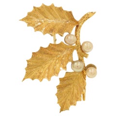 Holly-shaped brooch with yellow gold pearls