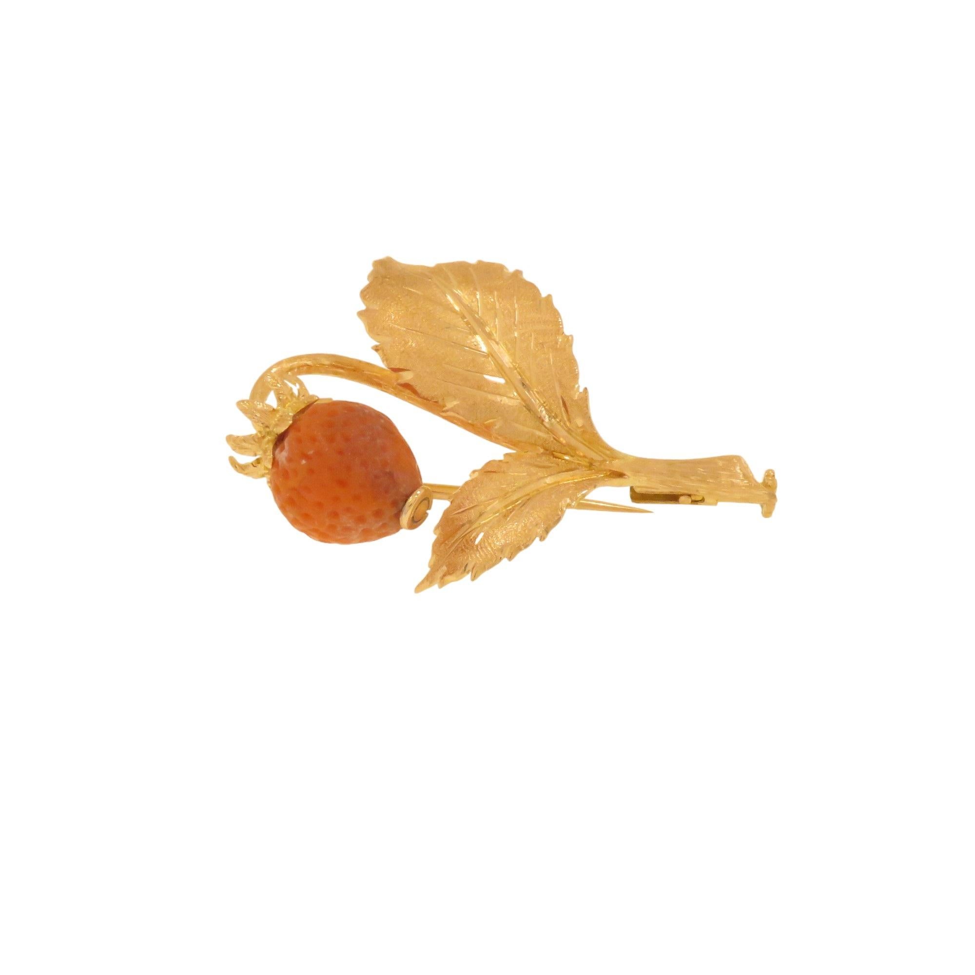 Magnifique broche représentant une fraise en corail avec des feuilles en or jaune 18 carats. Finement sculpté et gravé à la main par un orfèvre expérimenté. Produit entre 1960 et 1970. L'épingle  porte la marque de l'or 18k, mesure 36x24 mm et pèse