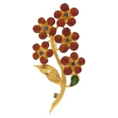 Floral brooch with blue sapphires and enamel in yellow gold