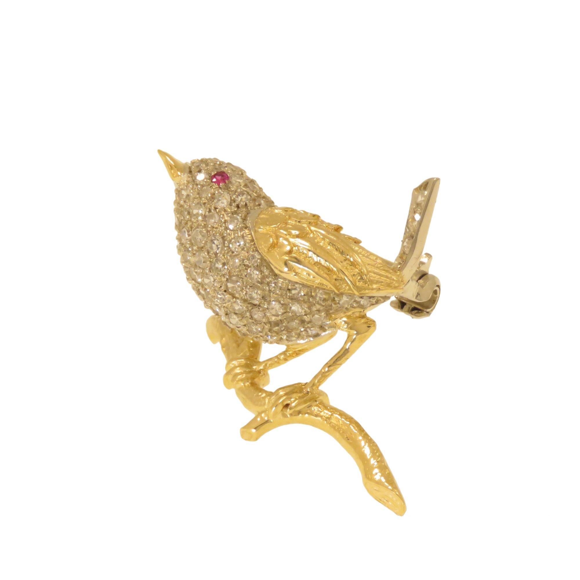 Elegant handcrafted bird-shaped brooch in 18K yellow and white gold with 72 diamonds of approximately 1.4 carats set on the body. The gold parts without diamonds such as the wing, beak, legs, and branch are crafted and finely engraved by hand. 