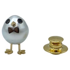 Spilla pulcino con papillon in oro 18Kt perla australiana e diamanti neri