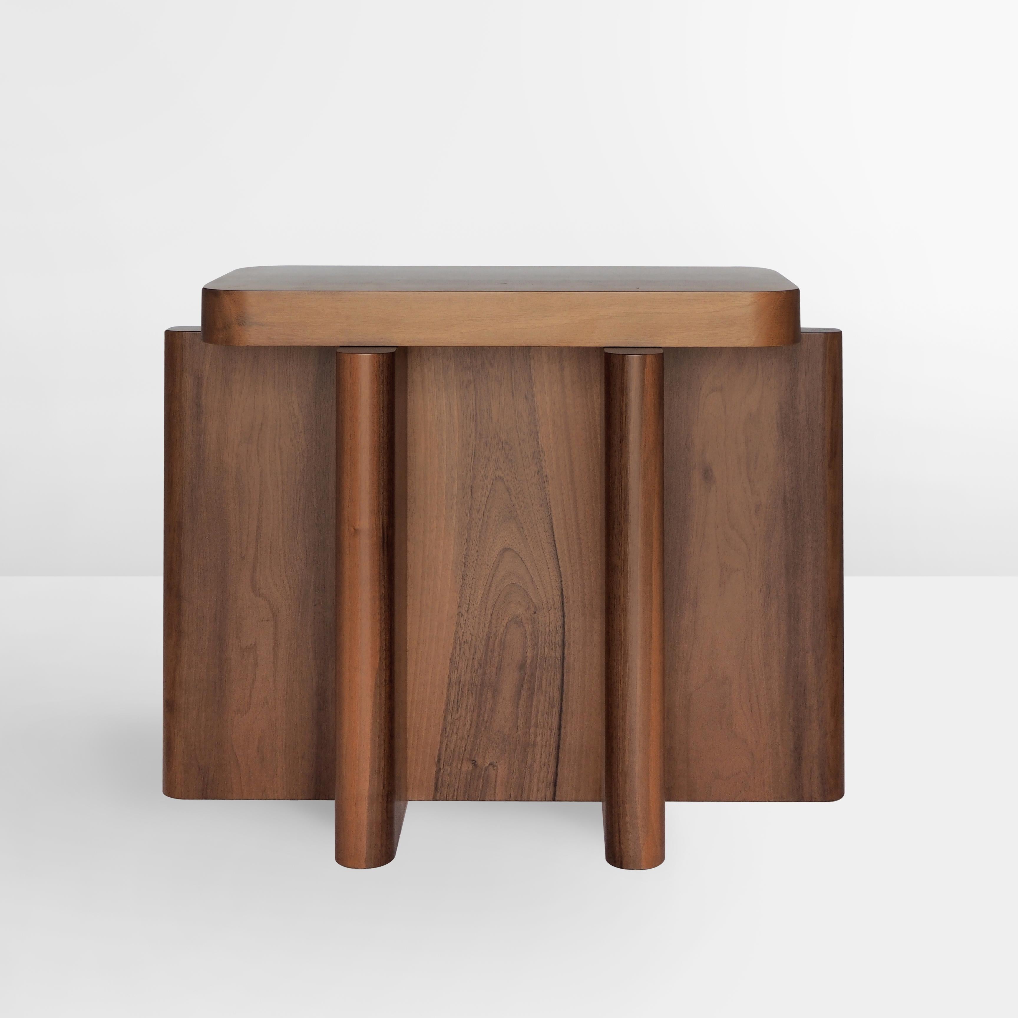 Spina is a collection of tables, seating and consoles characterized by a dense skeletal base that supports a smaller horizontal plane along its axis. This version comes in solid nut wood.*

The thicknesses and proportions of the intersecting