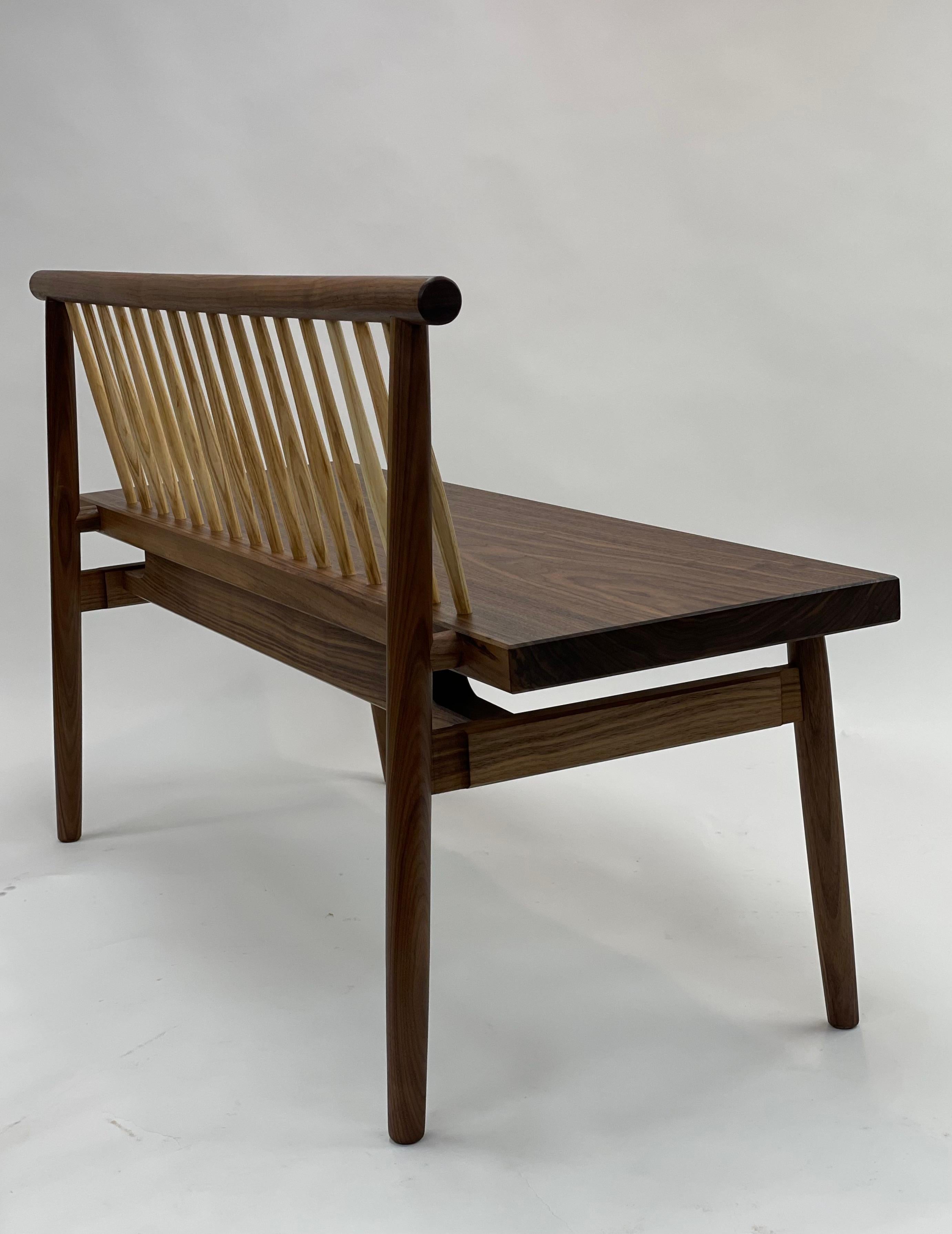 Contemporary walnut bench handmade by Brian Holcombe utilizing the techniques of traditional Windsor chair making combined with traditional mortise and tenon joinery similar to that utilized for timber framed structures. 

The bench is shown in