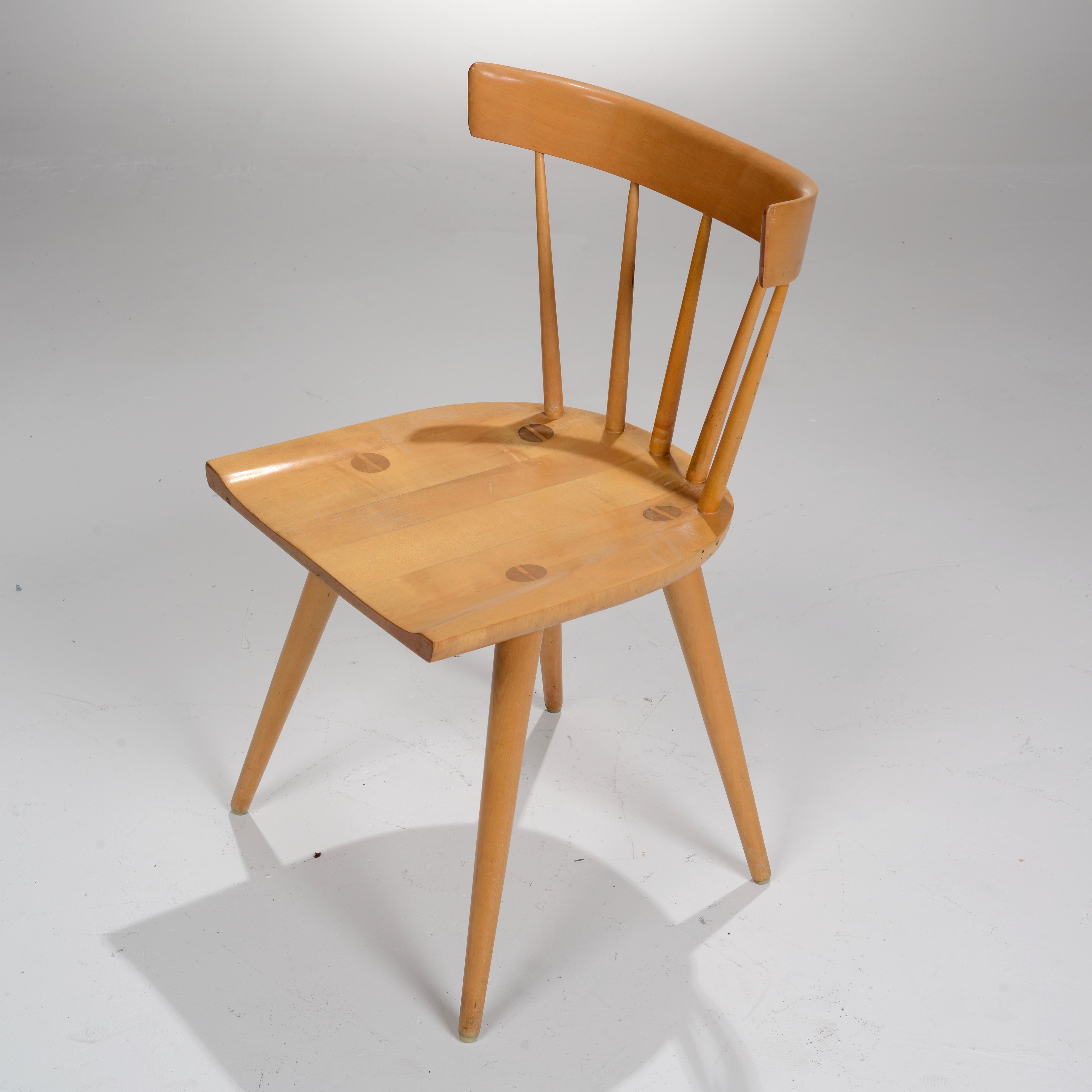 Maple spindle back dining chair from the Planner Group series designed by Paul McCobb and manufactured by Winchendon, Massachusetts. The seat rests atop four tapered legs and is inlaid with four oversize wooden screw motifs.
We currently have 10 in