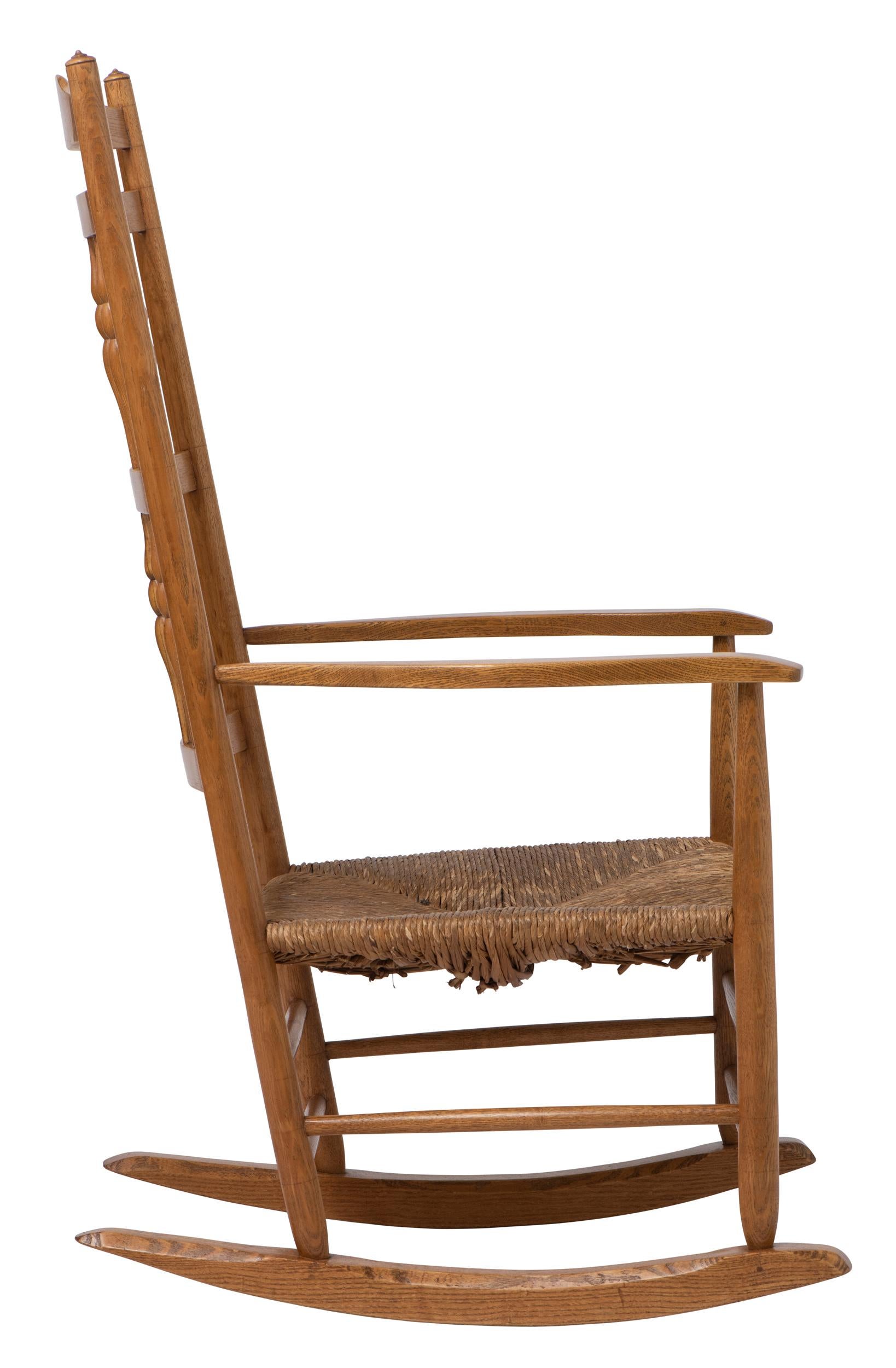 An Oak spindle back Rocking Chair by Neville Neal.
Designed by Ernest Gimson.
Rush seat.
Stamped to upright.
England circa 1920