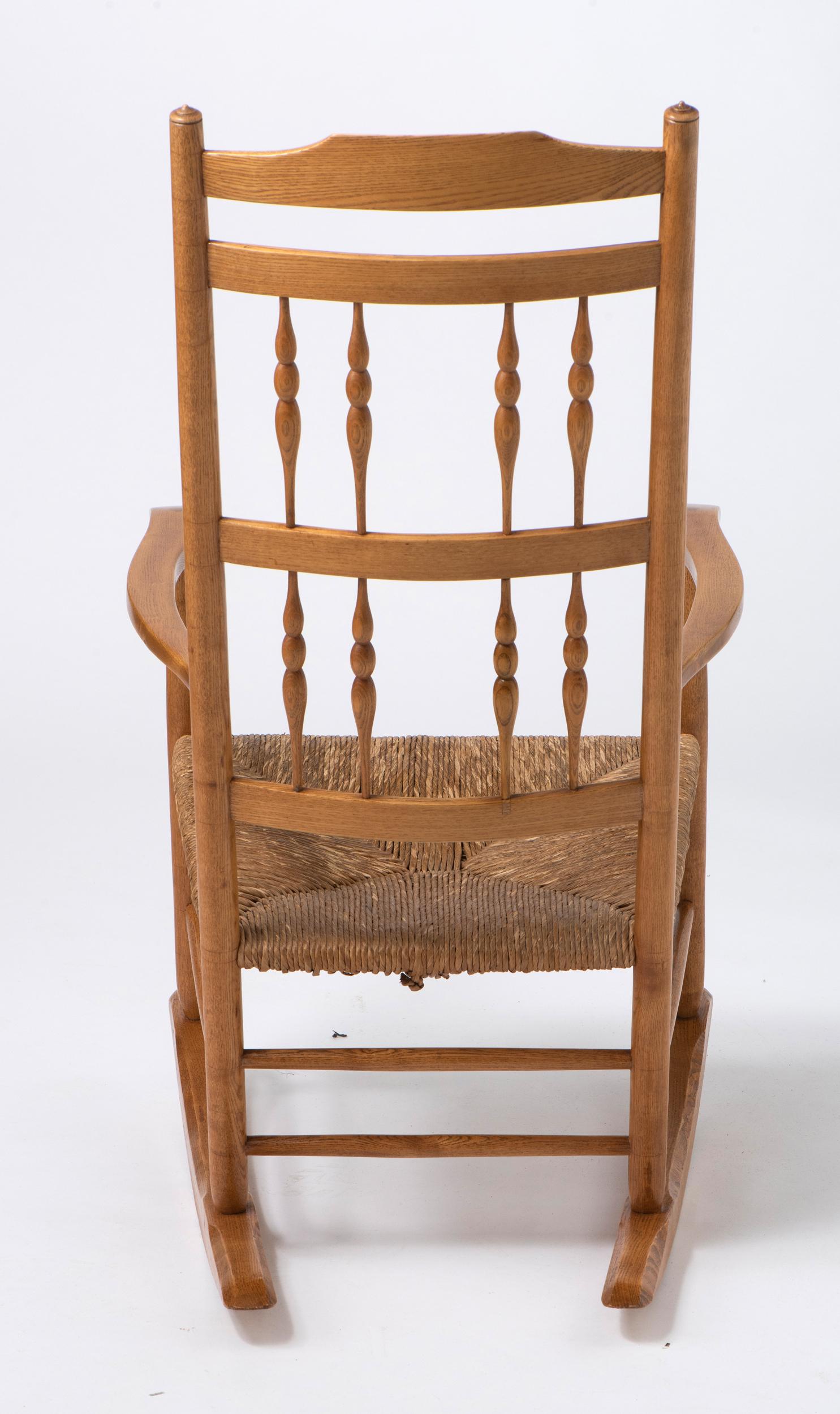 Spindle back Rocking Chair with rush seat by Neville Neal, England circa 1920. In Good Condition For Sale In Knutsford, GB